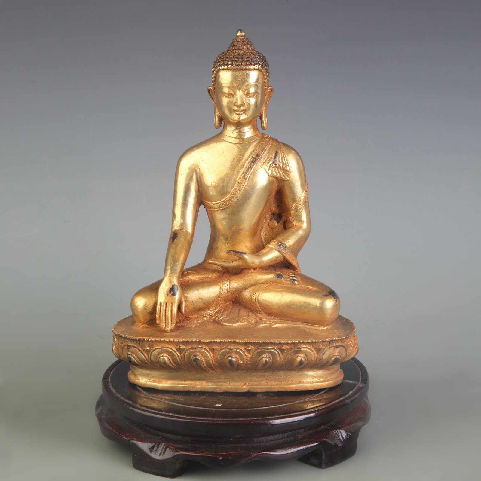 A FINE GILT BRONZE FIGURE OF SHAKYAMUNI BUDDHA: Qing Dynasty; Width: 6.0 inch; High: 8.6 inch ; wooden base for picture and display purpose only.