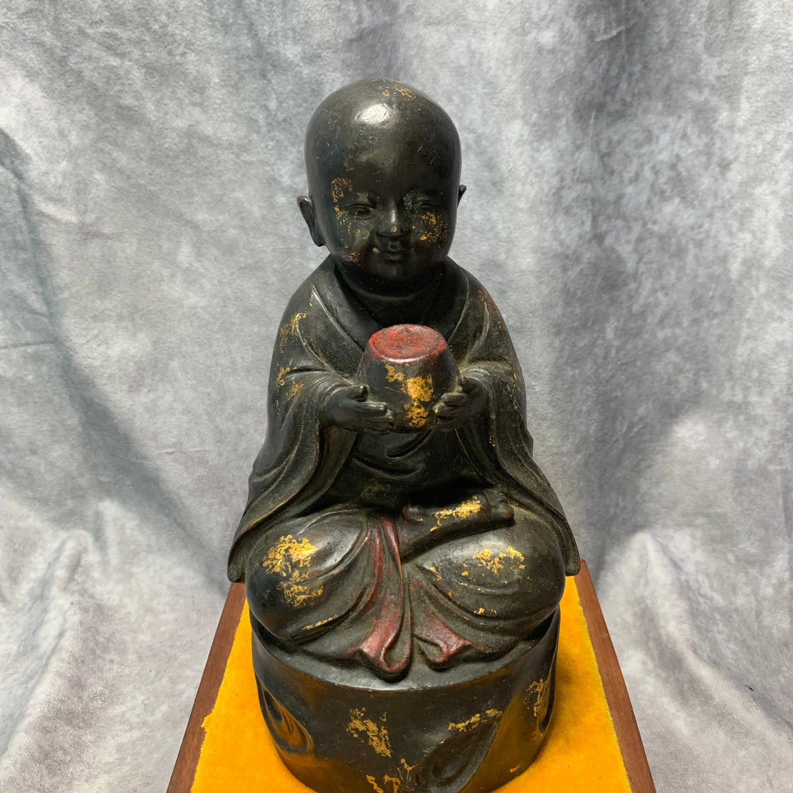 A GILT-BRONZE SEATED FIGURE OF A YOUNG MONK: Ming Dynasty Style; Long: 4.5 inch; High: 8.9 inch. Wooden base for picture and display only. ; wooden base for picture and display purpose only.