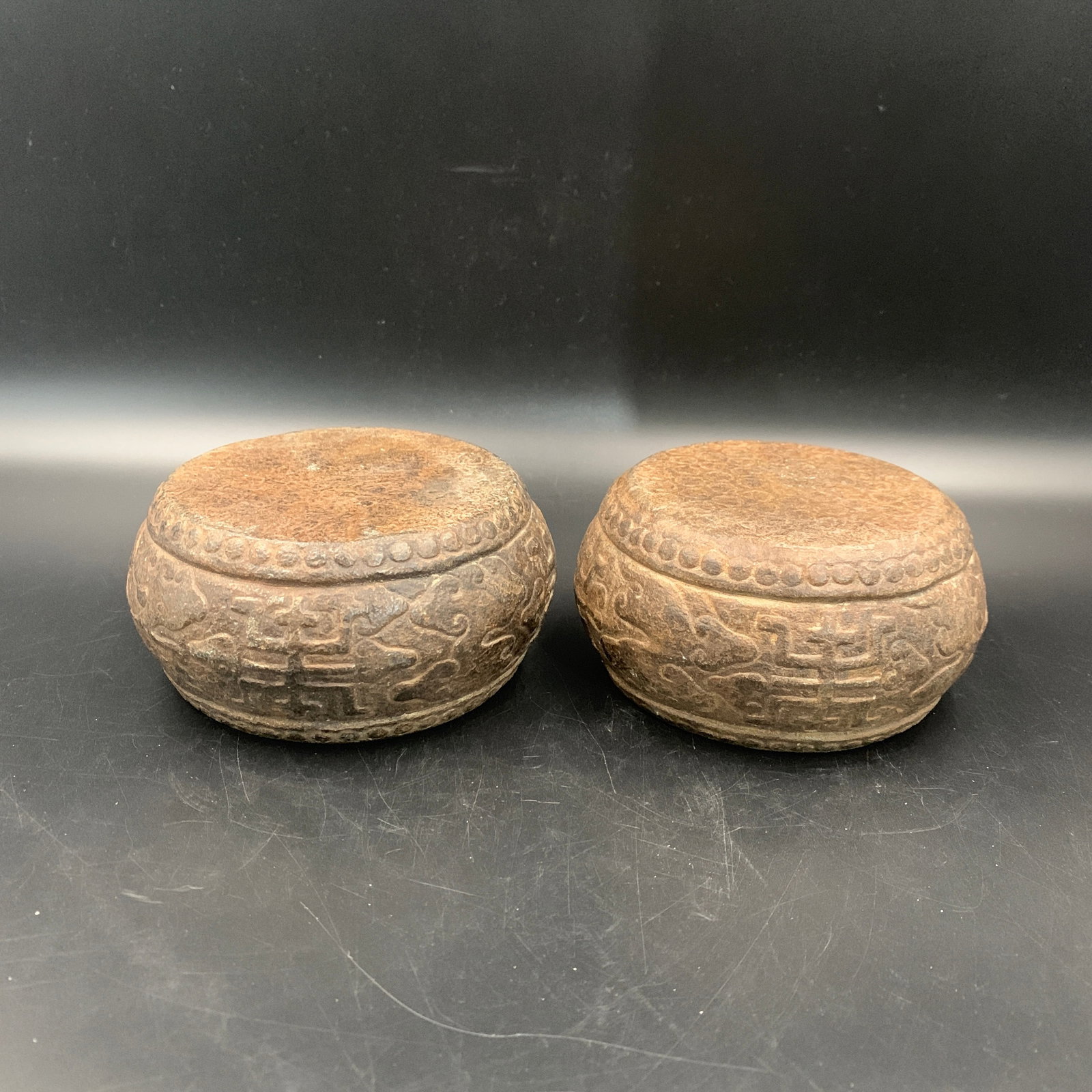 PAIR OF CARVED STONE CLOUD-SCROLL PATTERN BASES: Modern; High: 2.7 inch; Diameter: 5.4 inch;