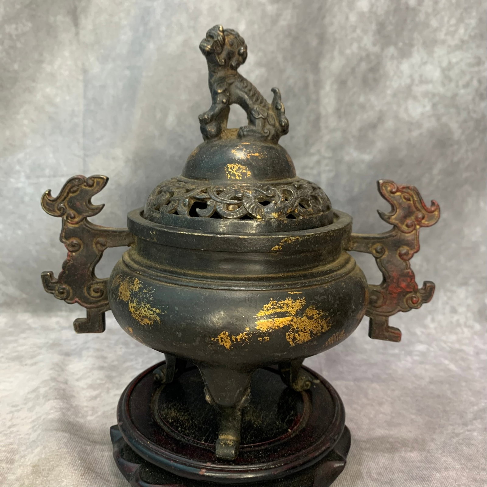 GILT-BRONZE CHILONG-HANDLE TRIPOD CENSER WITH BUDDHIST LION FINIAL: Qing Dynasty; High: 7.7 inch; Width: 7.7 inch; Long: 5.0 inch ; wooden base for picture and display purpose only.