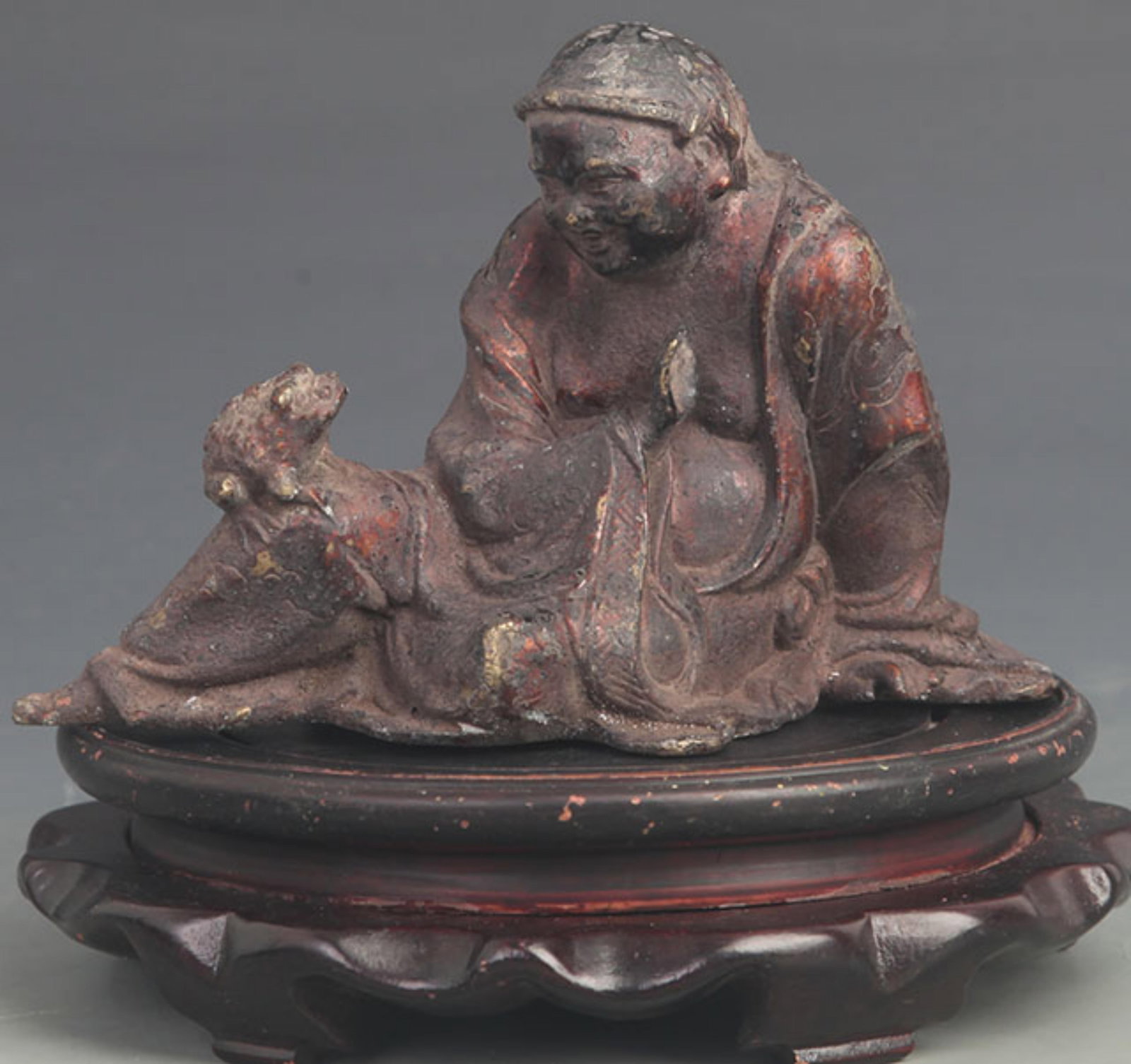 A BRONZE GILT FIGURINE OF LIU HAI PLAYING WITH A MONEY TOAD: 19th Century; High: 5.00 inch; Long: 7.25 inch; wooden base for picture and display purpose only.