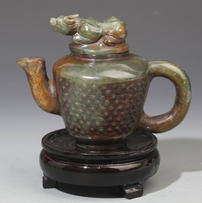 A FINELY CARVED GREEN AND RUSSET JADE TEA POT: 20th Century, H:3.3 in × W:4.5 in