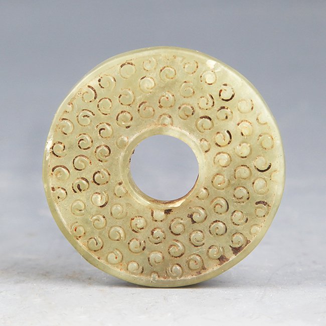 AN OLD AND FINELY CARVED GREENISH WHTIE JADE: West Han Dynasty, D:1.8 in
