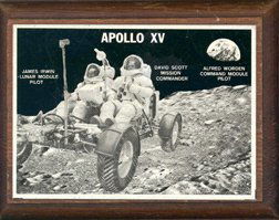 Apollo 15 Plaque: (4.25 x 3.25 x .75"). This wooden plaque bears a chrome and black color metal plate with astronauts David Scott and James Irwin in the Lunar Module. Good condition.
