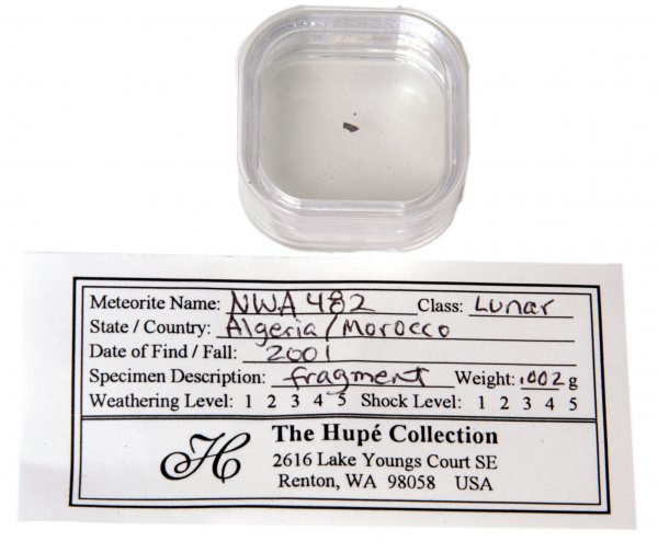 Lunar Meteorite Fragment: According to the small description tag accompanying this lot, this meteorite fragment (approx. 1/8" long and mounted in a Lucite case 1.5" square and .75" tall) is of lunar material, was found in Alge