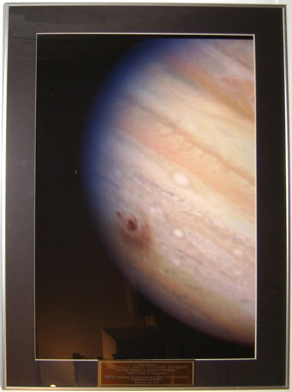 Large Matted and Framed Photograph of Jupiter: (matted and framed to 19 x 28") Mounted with a black mat in a silver metal frame. The plaque reads "Presented to Rockwell Space Systems Division for their dedication to education through the "Discover
