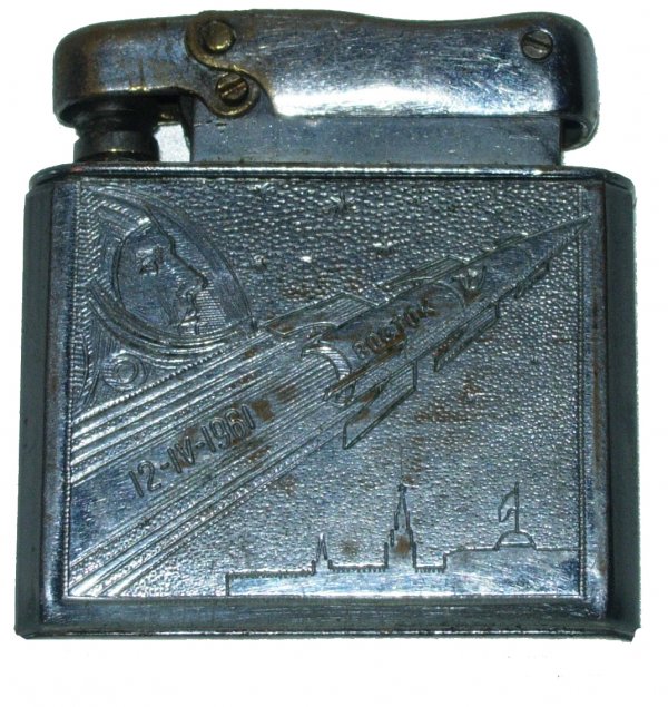Vostok 1 Gagarin Commemorative Cigarette Lighter: A silver-toned cigarette lighter commemorating Gagarin's flight of Vostok 1. The piece bears a profile portrait of Gagarin and an accelerating rocket over Moscow. Inscribed with the launch date. Rare 