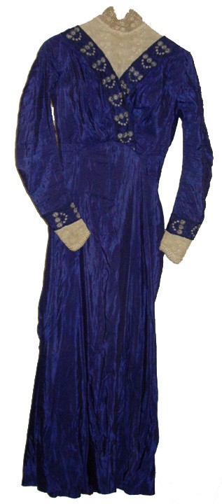 Womans 1912 Edwardian Blue Silk Gown Dress: A Striking 1912 Edwardian blue silk gown. The bodice has a high neck lace insert and is decorated with blue and white embroidered flowers. The sleeve cuffs are decorated in the same manner. The skirt 