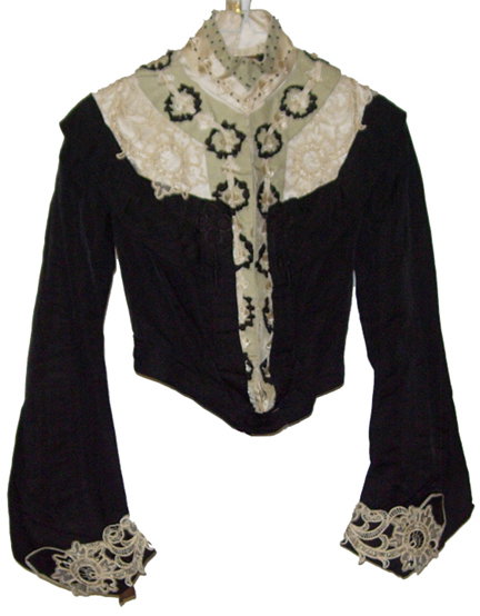 Magnificent Womans Edwardian Black Bodice: Fashioned in polished black cotton, this bodice is embellished with magnificent cutwork lace in ivory and spring green velvet trim down the front of the bodice and around the neck. Black tassels adorn