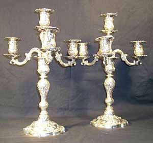 Pair of silver 4-light candelabra in the: Pair of silver 4-light candelabra in the rococo style, with shell and floral scones, c-srcoll branches and baluster stem, with a shaped circular base, all over decoration with floral sprays and c-scro