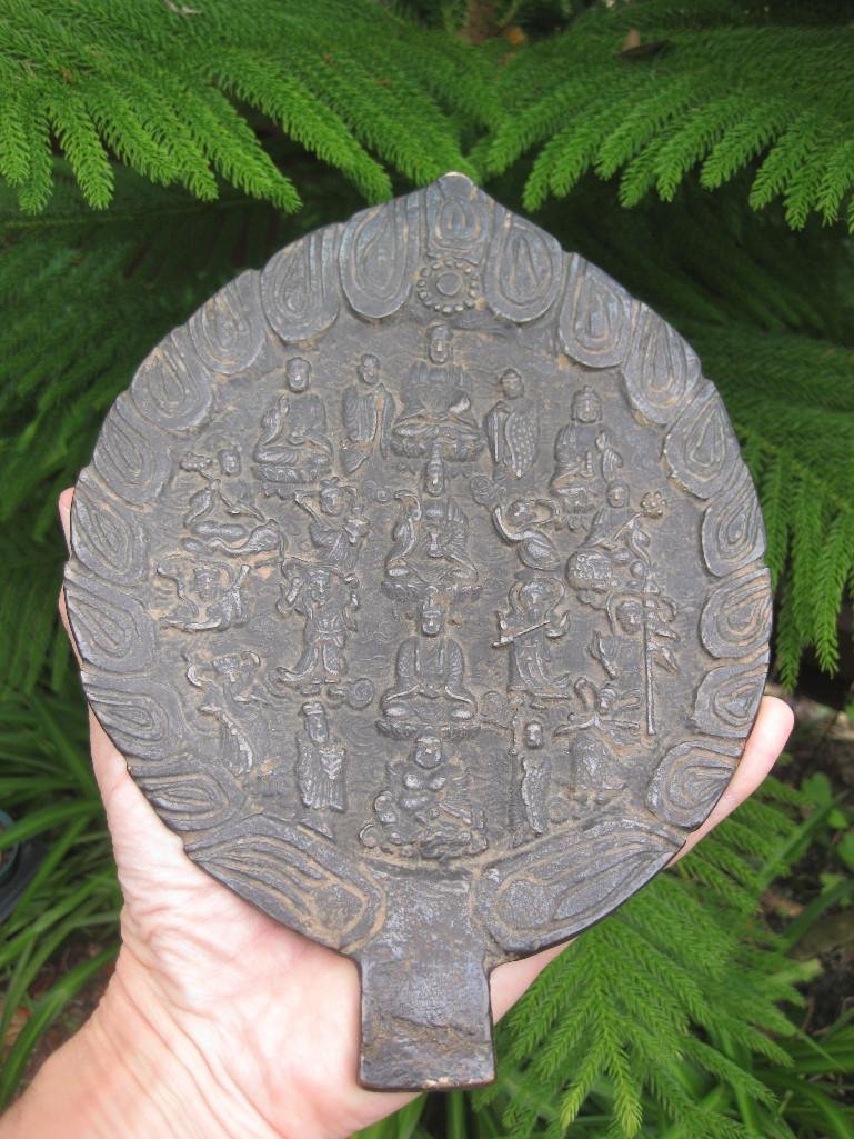 Chinese Buddhist antique bronze hand mirror: Chinese Buddhist antique bronze hand mirror. An archaic, leaf-shaped, hand mirror with one polished face, panel of figural scenes to the reverse within a border of stylized flames. Weight: 985 grams =