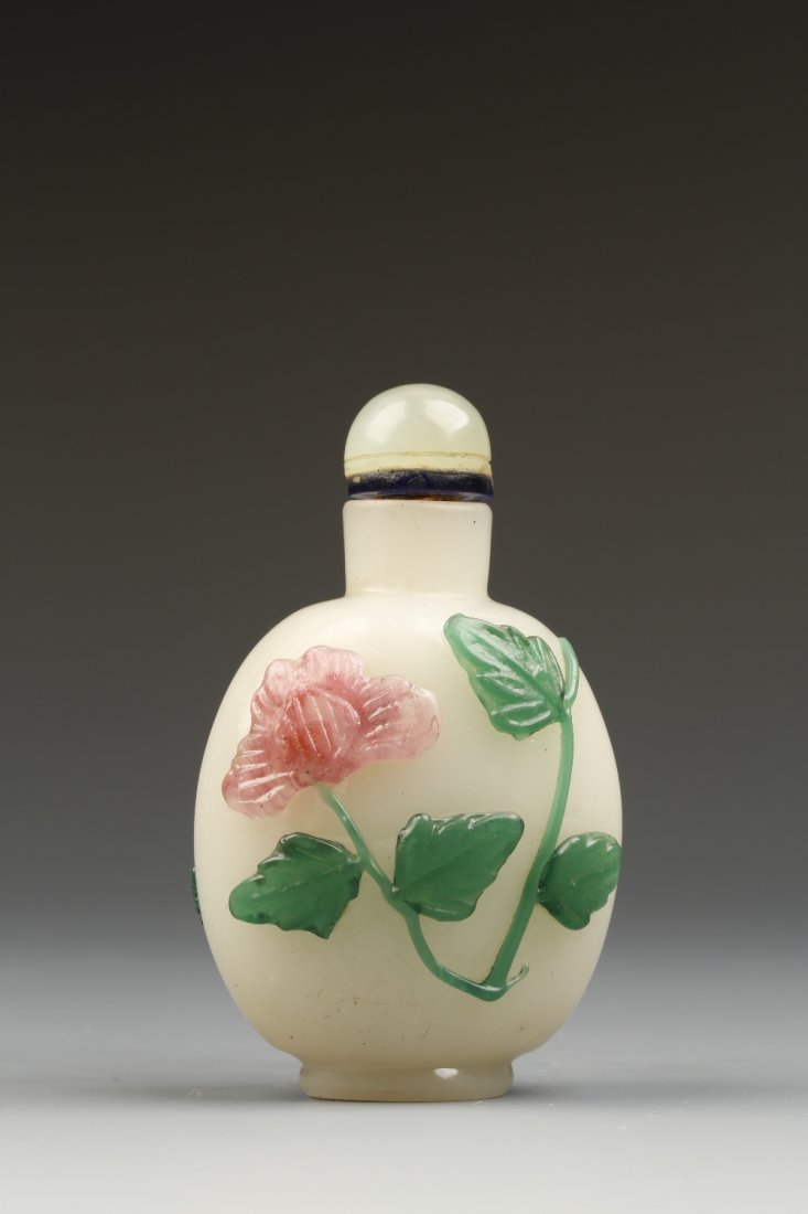 A CELADON GLASS SNUFF BOTTLE, the rounded body applied: A CELADON GLASS SNUFF BOTTLE, the rounded body applied with green leaves and pink flowers, 1880-1920, domed stopper, 2.75" high Provenance: The Anthony Bate Collection of Chinese Snuff Bottles and Wor