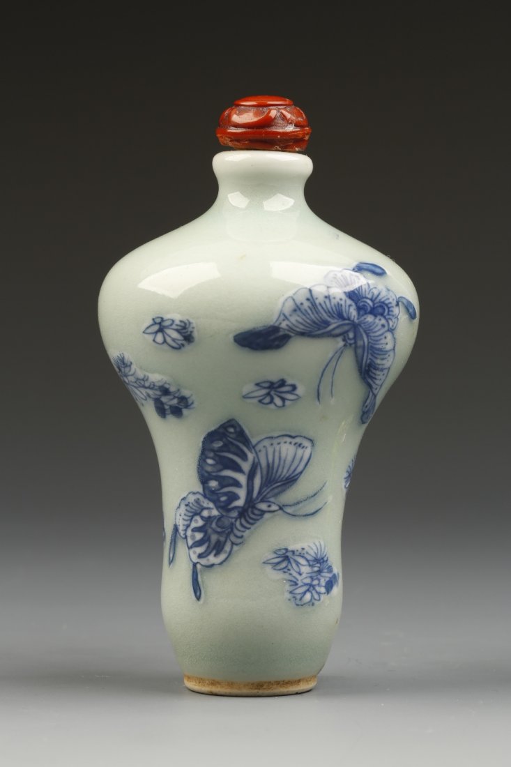 A CELADON GROUND PORCELAIN SNUFF BOTTLE of meiping form: A CELADON GROUND PORCELAIN SNUFF BOTTLE of meiping form, decorated in relief with blue and white butterflies, 1820-1880, patterned stopper, 3.25" high Provenance: The Anthony Bate Collection of Chines