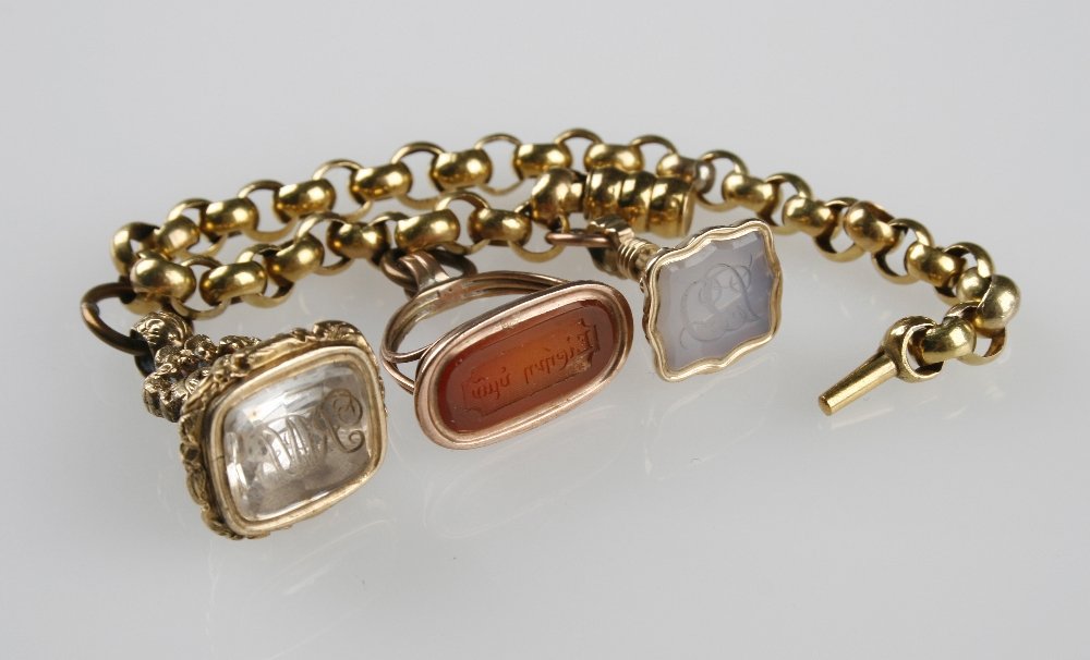 A GILT AND CORNELIAN SET INTAGLIO SEAL, two other seals: A GILT AND CORNELIAN SET INTAGLIO SEAL, two other seals and a gold coloured metal link bracelet (4)¦