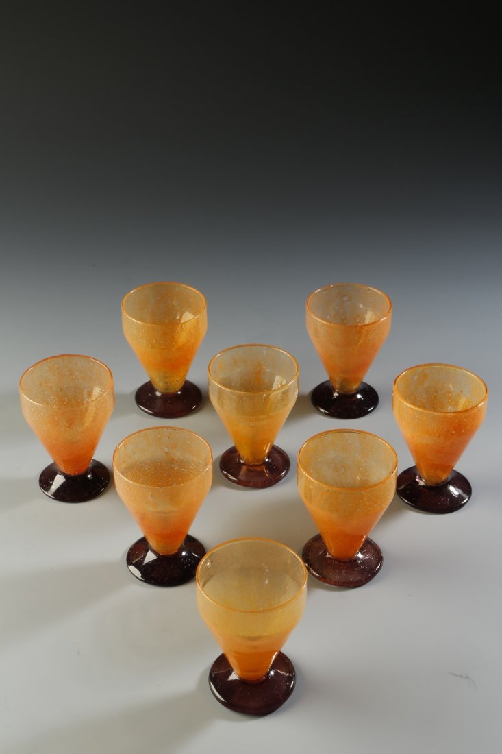DAUM NANCY: A SET OF EIGHT ART DECO GLASSES with orange: DAUM NANCY: A SET OF EIGHT ART DECO GLASSES with orange tapering bowls and amethyst bases, each with engraved signature 'Daum, Nancy', 3" high (8). See illustration