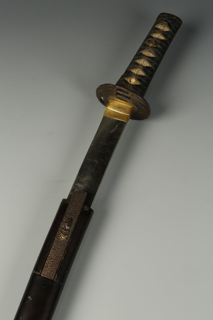 A JAPANESE WAKIZASHI, with a plain lacquered saya with : A JAPANESE WAKIZASHI, with a plain lacquered saya with a small dagger to the side, the iron tsuba before a shagreen and fabric tsuka, the blade 18" long, the whole piece 25" long overall¦