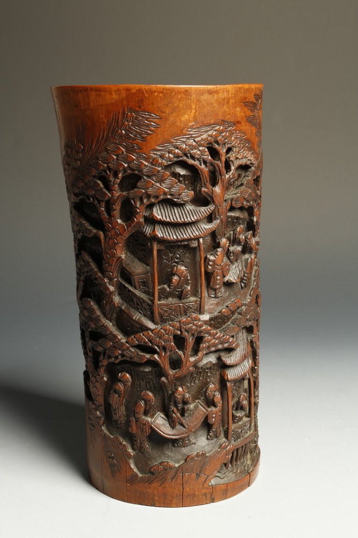 A CHINESE BAMBOO BRUSH POT decorated in high relief wit: A CHINESE BAMBOO BRUSH POT decorated in high relief with figures in a bamboo grove and the other side with further figures and pavilions amongst trees, late Qing/Republic, 11.25" high¦