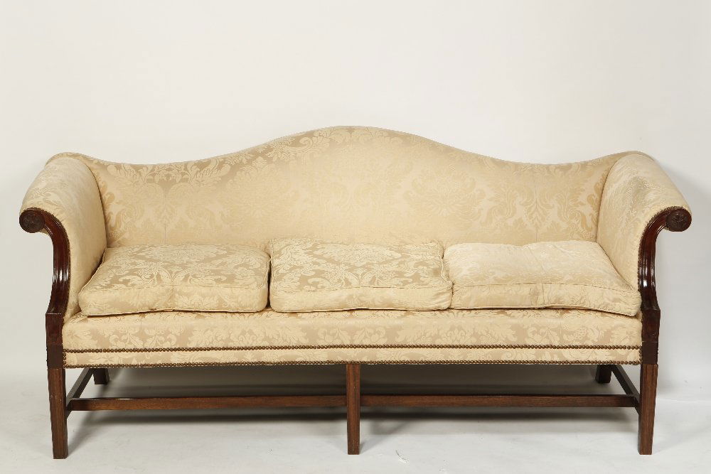A PAIR OF GEORGE III STYLE SETTEES with arched backs an: A PAIR OF GEORGE III STYLE SETTEES with arched backs and scrolling arm rests with foliate carved and moulded frames, on square section moulded legs with 'H'-form stretchers, upholstered in cream colou