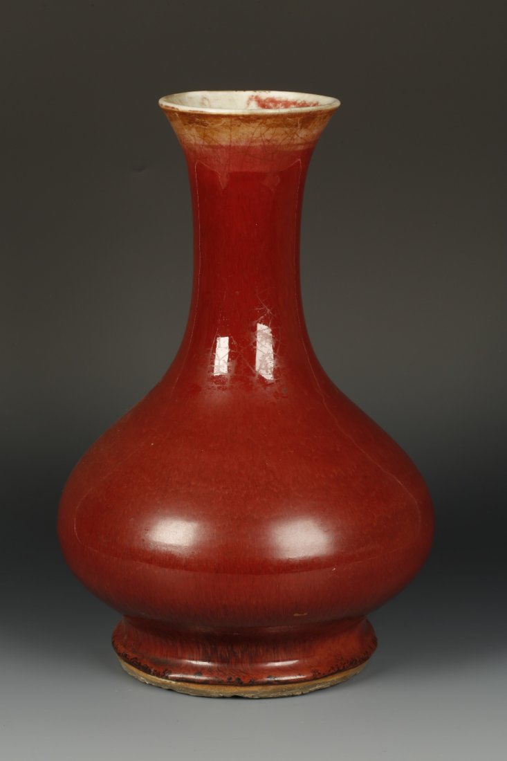 A SANG DE BOEUF BOTTLE VASE, the rich dark red glaze: A SANG DE BOEUF BOTTLE VASE, the rich dark red glaze pulling downwards from the top rim and pooling near the base, Qing, 13.5" high