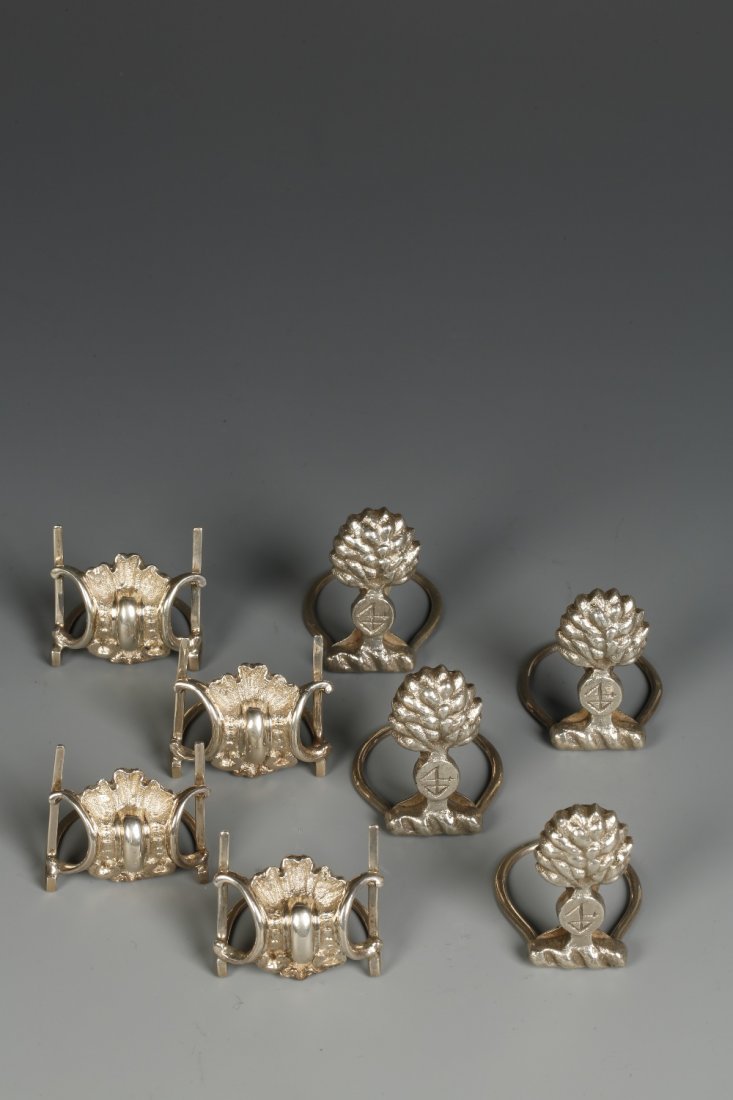A SET OF FOUR MENU CARD HOLDERS modelled in the form of: A SET OF FOUR MENU CARD HOLDERS modelled in the form of trees with hoop stems, by Charles Stuart Harris & Sons, London 1934, 2" high, and a set of four scroll-style Victorian menu holders (c.7.5oz) (8