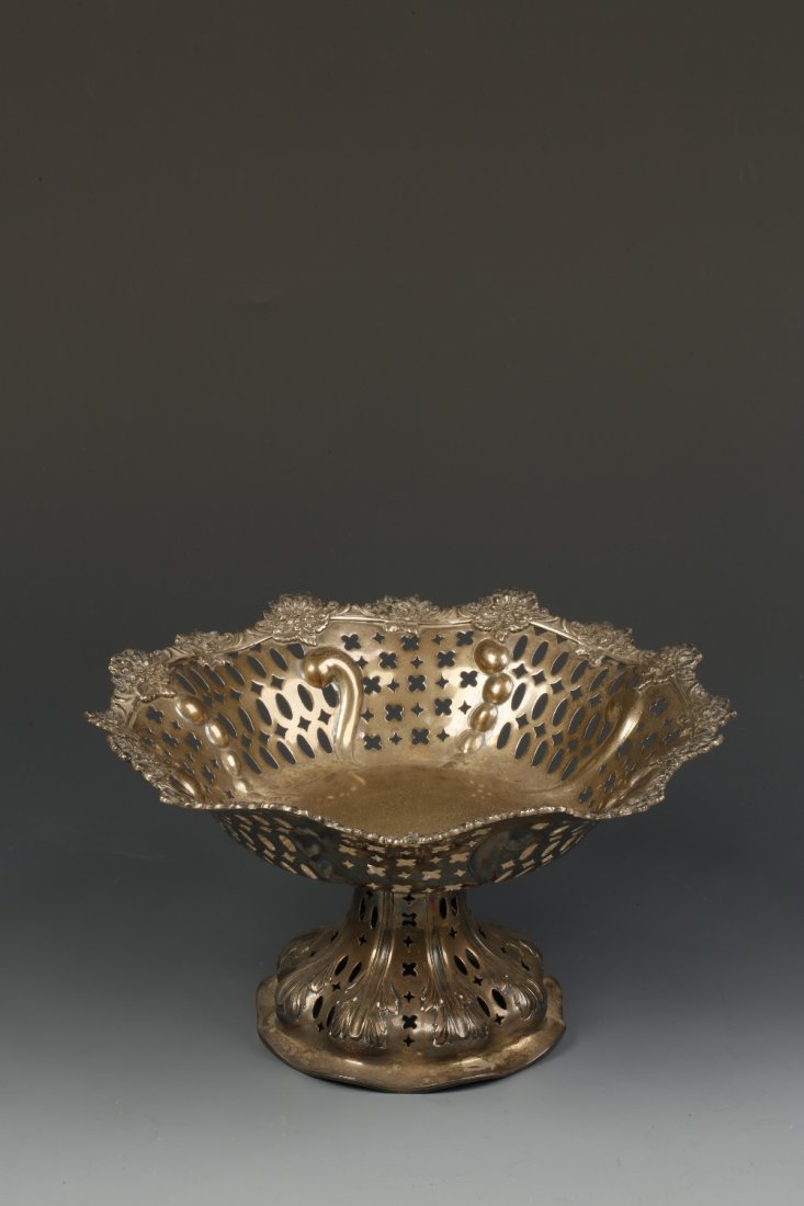 A VICTORIAN PEDESTAL DISH of shaped circular form with: A VICTORIAN PEDESTAL DISH of shaped circular form with pierced borders, on a spreading circular foot, by Charles Stuart Harris, London 1886, 5" high, (c.15oz)