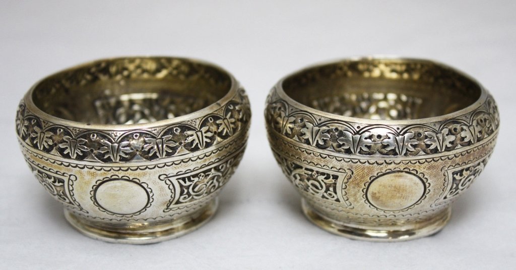 Pair English Sterling Salt Bowls Dishes c. 1874: Pair of sterling silver Cellini style ornate open salt bowls or cellars, made in London, England, c. 1874. The pieces are fully chased with an ornate Near Eastern design. Approximate Size: 2 1/8" diam