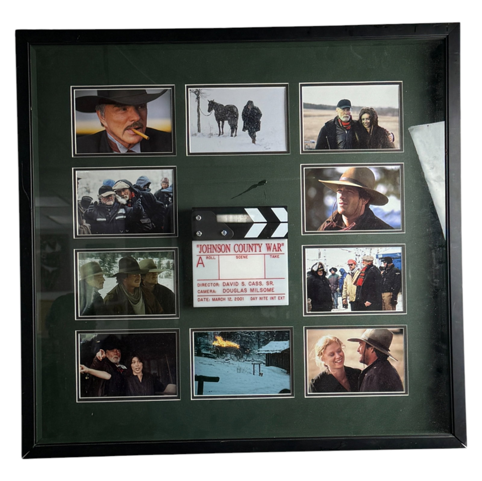 Framed Johnson County War Film Memorabilia with Clapper: Framed display featuring photographs and memorabilia from the 2001 TV miniseries 'Johnson County War'. Includes images, clapper board, and cast/crew stills. Private collector item.