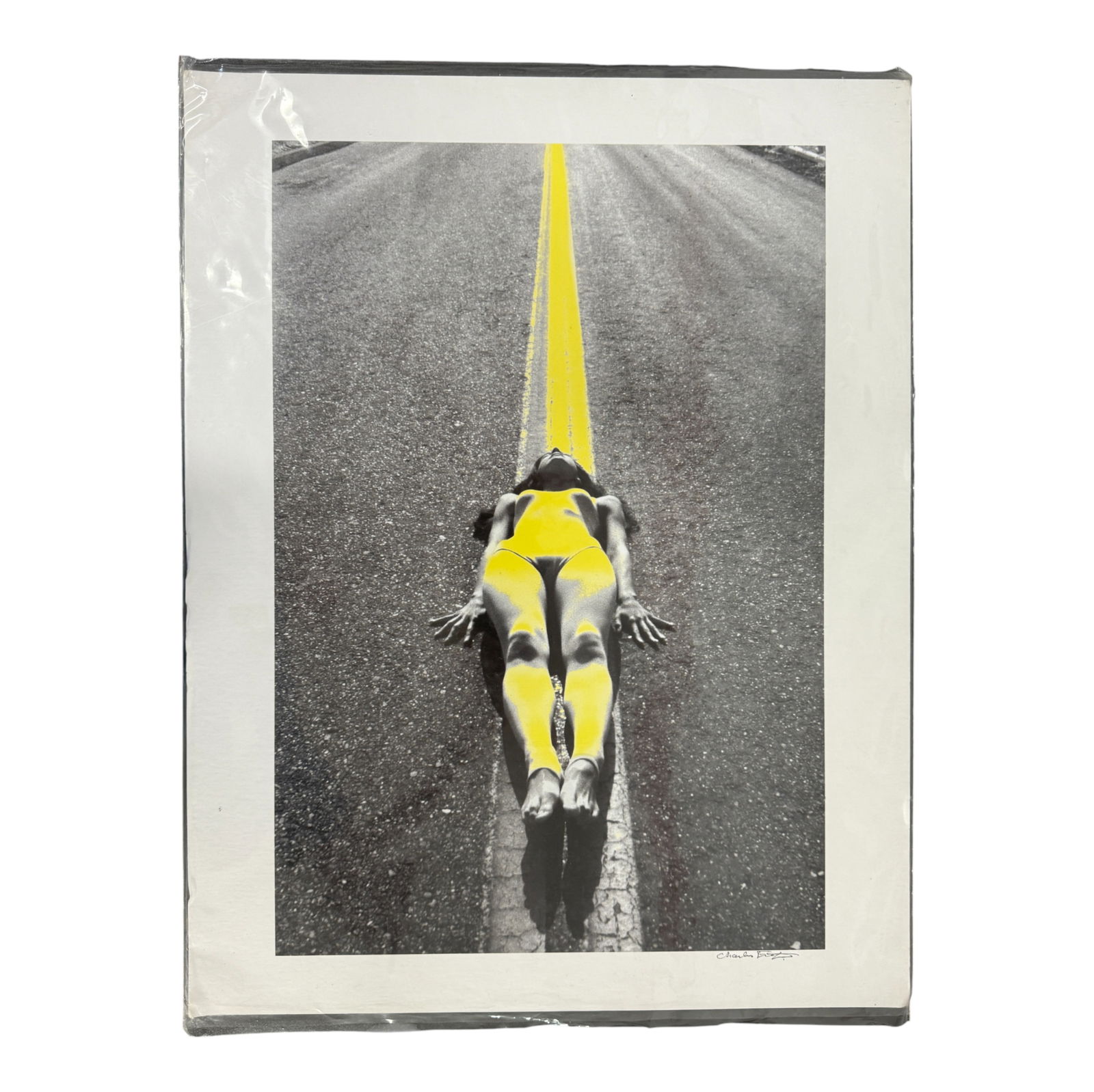 Charles Jourdan Fashion Photography: Bold modern photographic print depicting a model posed on a road with yellow painted line, signed lower right.