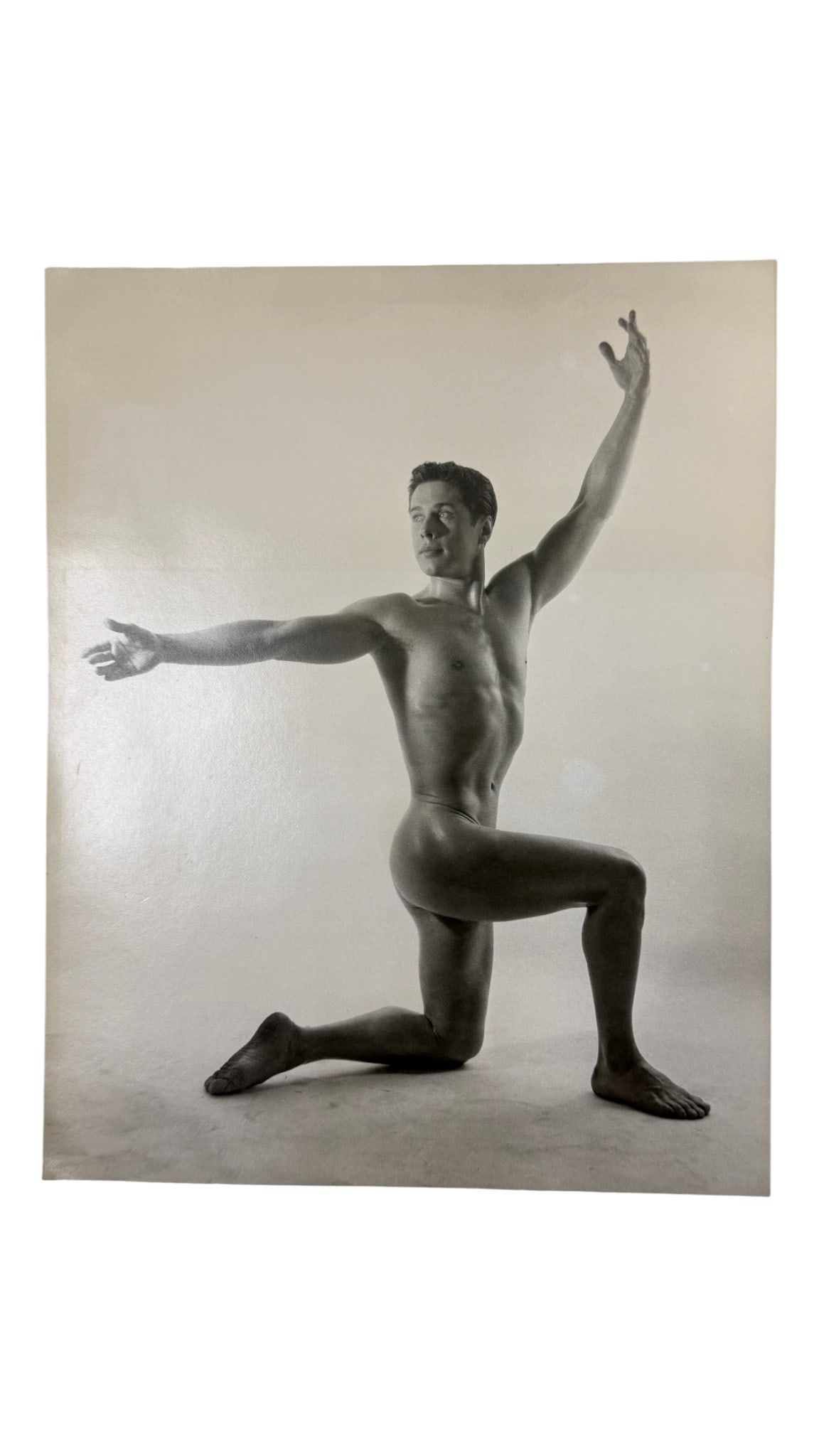 Large Format Male Nude Photograph: Oversized studio photograph of nude male model in a kneeling physique pose. Silver gelatin print, circa 1950s.