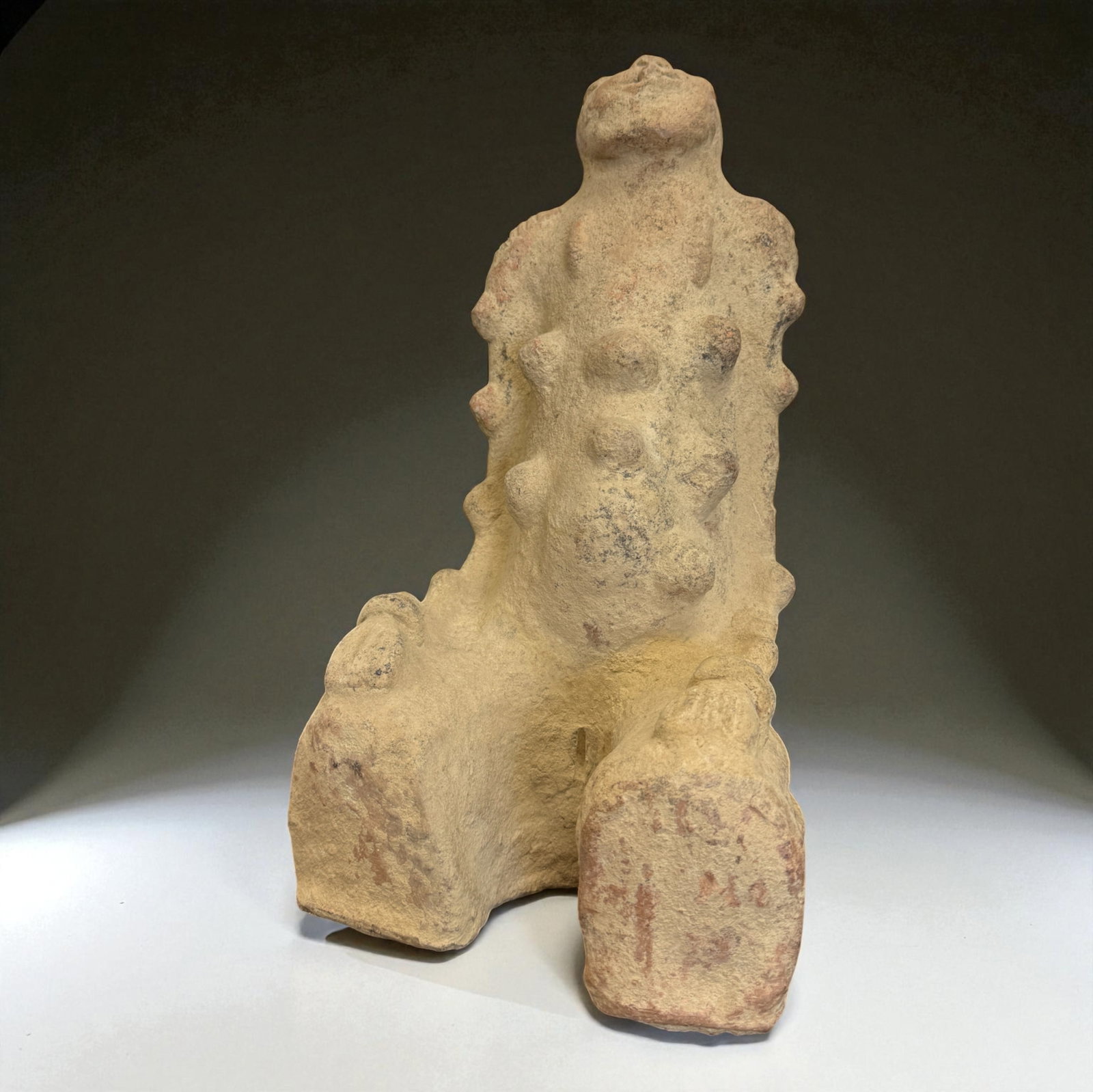 African Terracotta Fertility Figure: Ancient-style African terracotta fertility figure with highly textured surface and multiple protruding nodules, seated in a powerful abstract pose suggesting ritual significance. Provenance: Beverly H