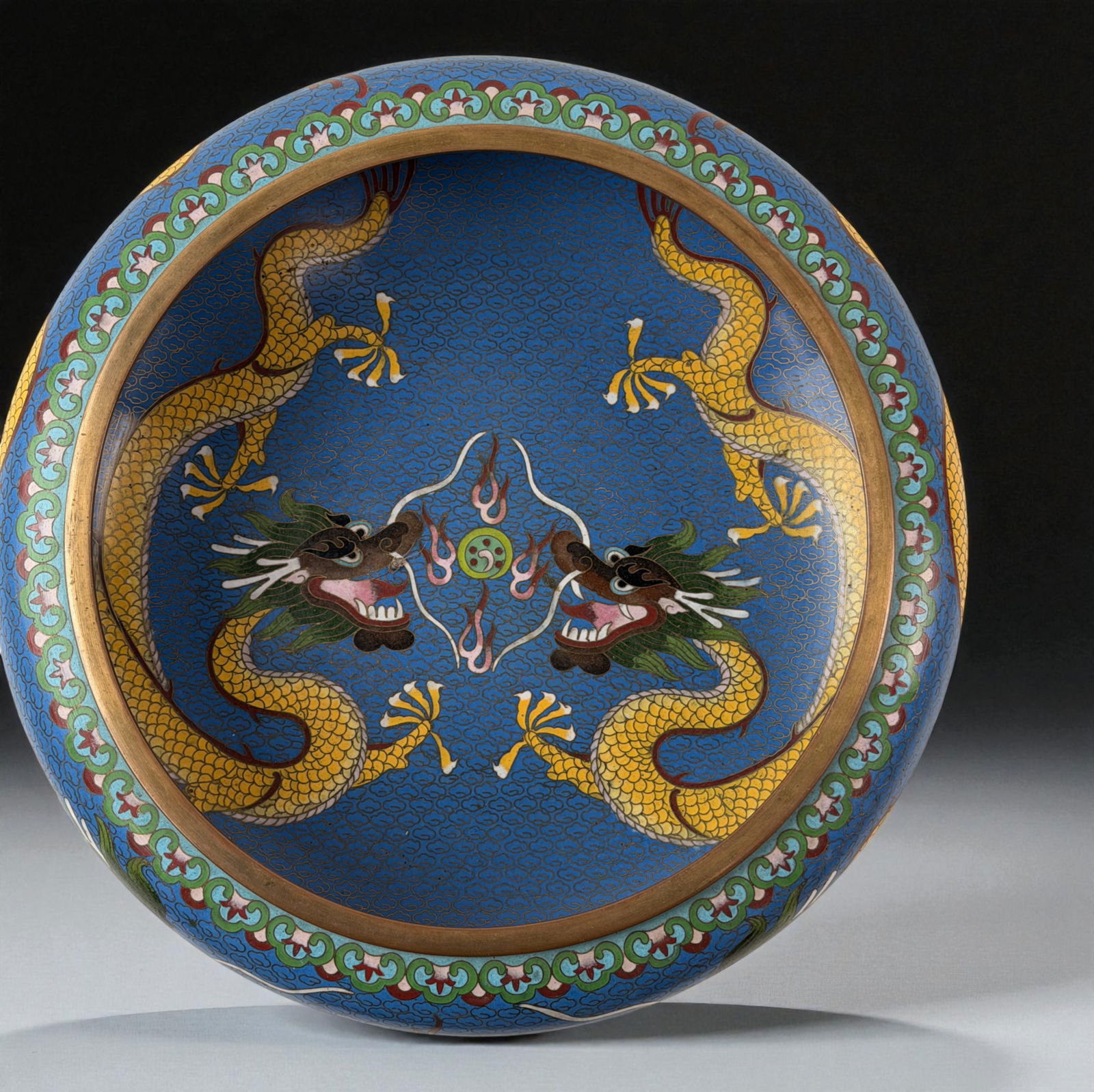 Chinese Cloisonne Dragon Dish: Cloisonne dish with twin yellow dragons on blue ground and floral border. 12"