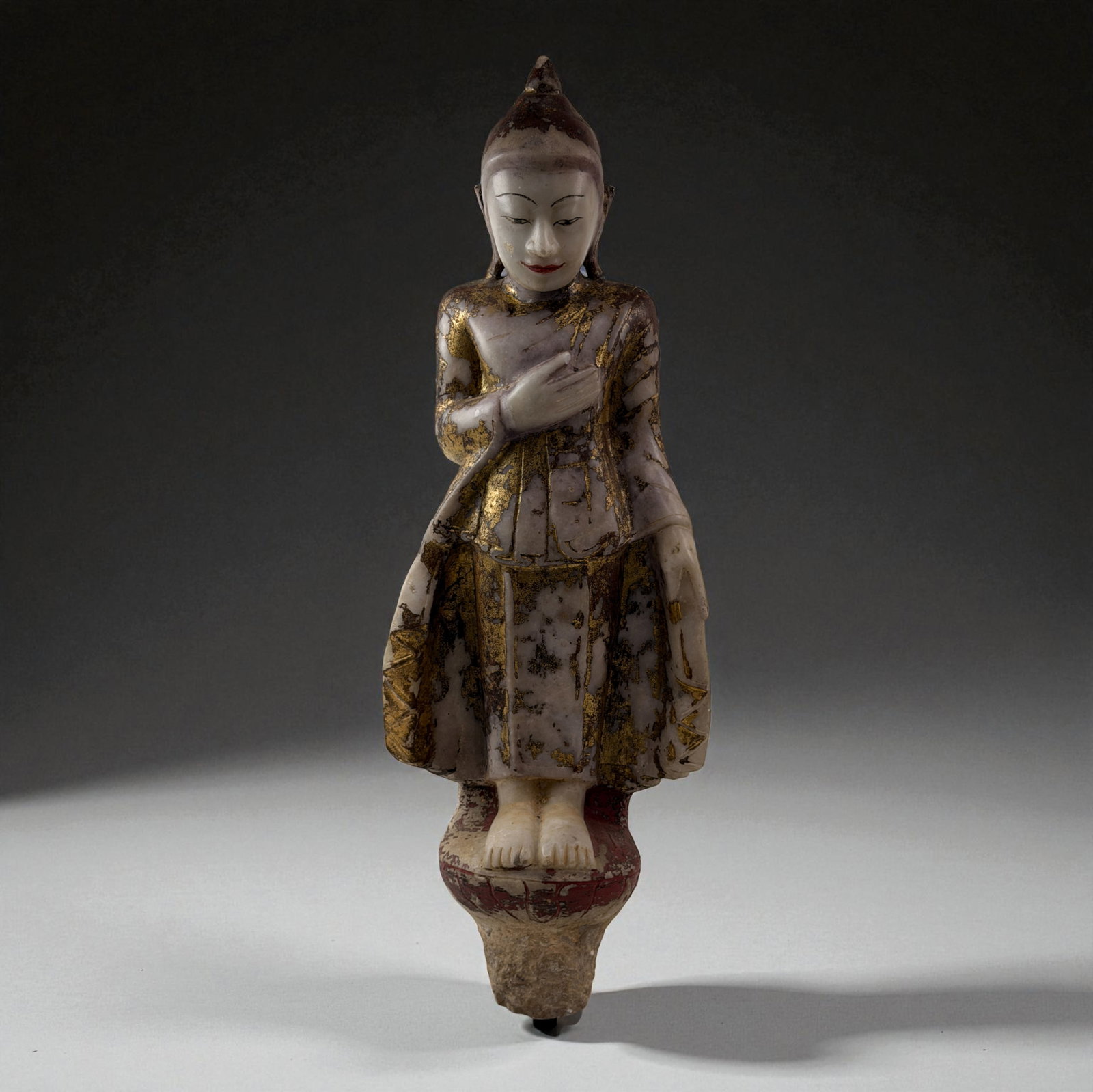 Standing Marble Buddha Figure: Standing Marble Buddha figure with traces of gilding and traditional robe patterns.Provenance: Beverly Hills Barakat Gallery Collection.