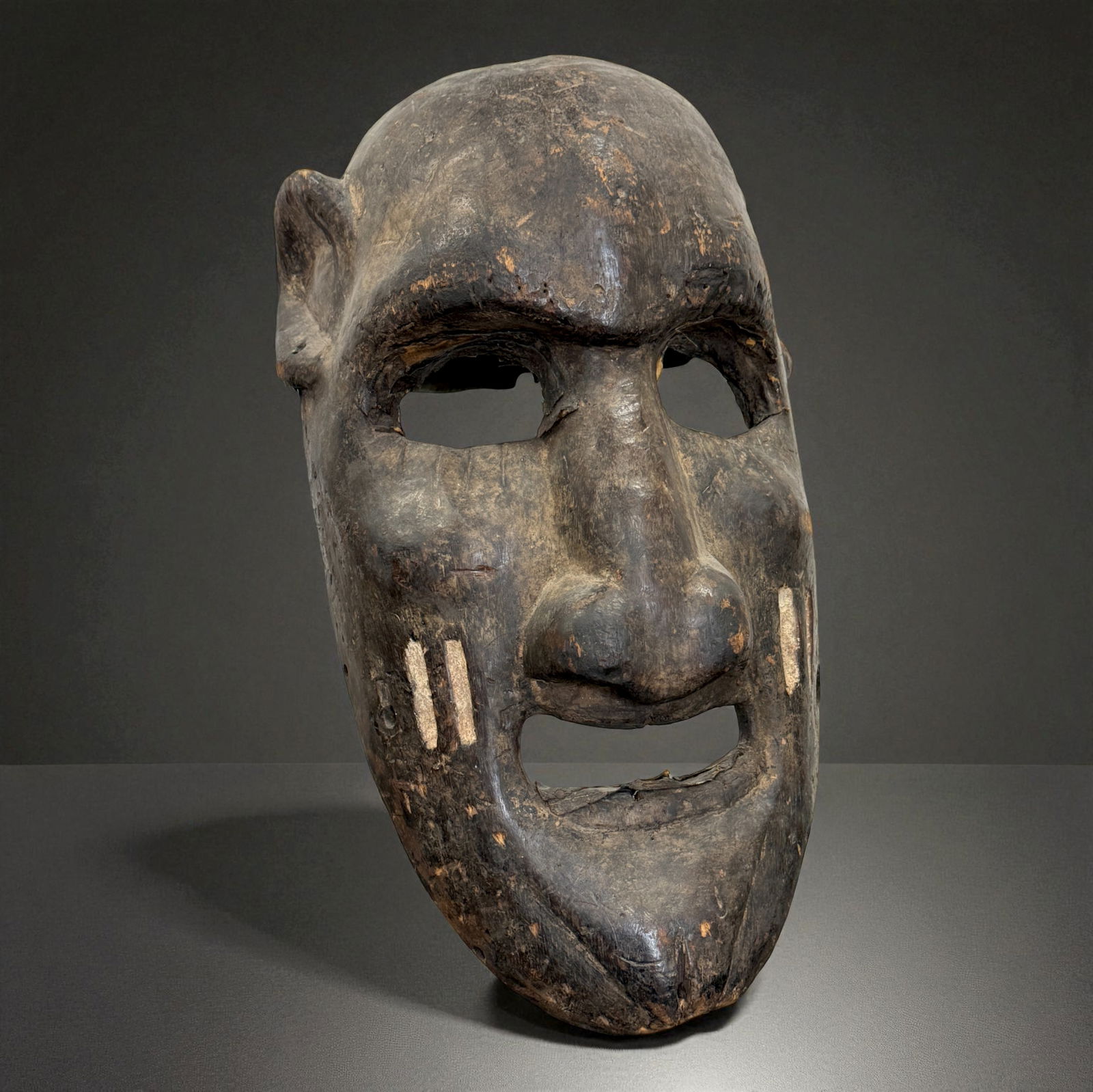 African Carved Mask: African carved wooden figure or mask displaying traditional regional craftsmanship, likely 19th?20th Century. Provenance: Beverly Hills Barakat Gallery Collection. 19" inches