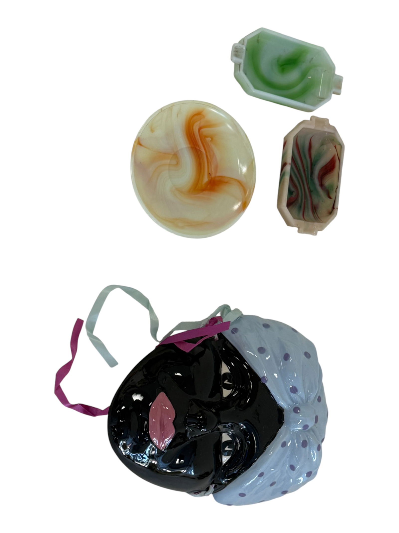 Marbled Glass Dishes & Figural Wall Mask: Lot including marbled glass dishes in green and amber tones, together with a Black Americana figural wall mask with ribbon hanger. Mixed mid-20th-century decorative objects. Condition varies with surf