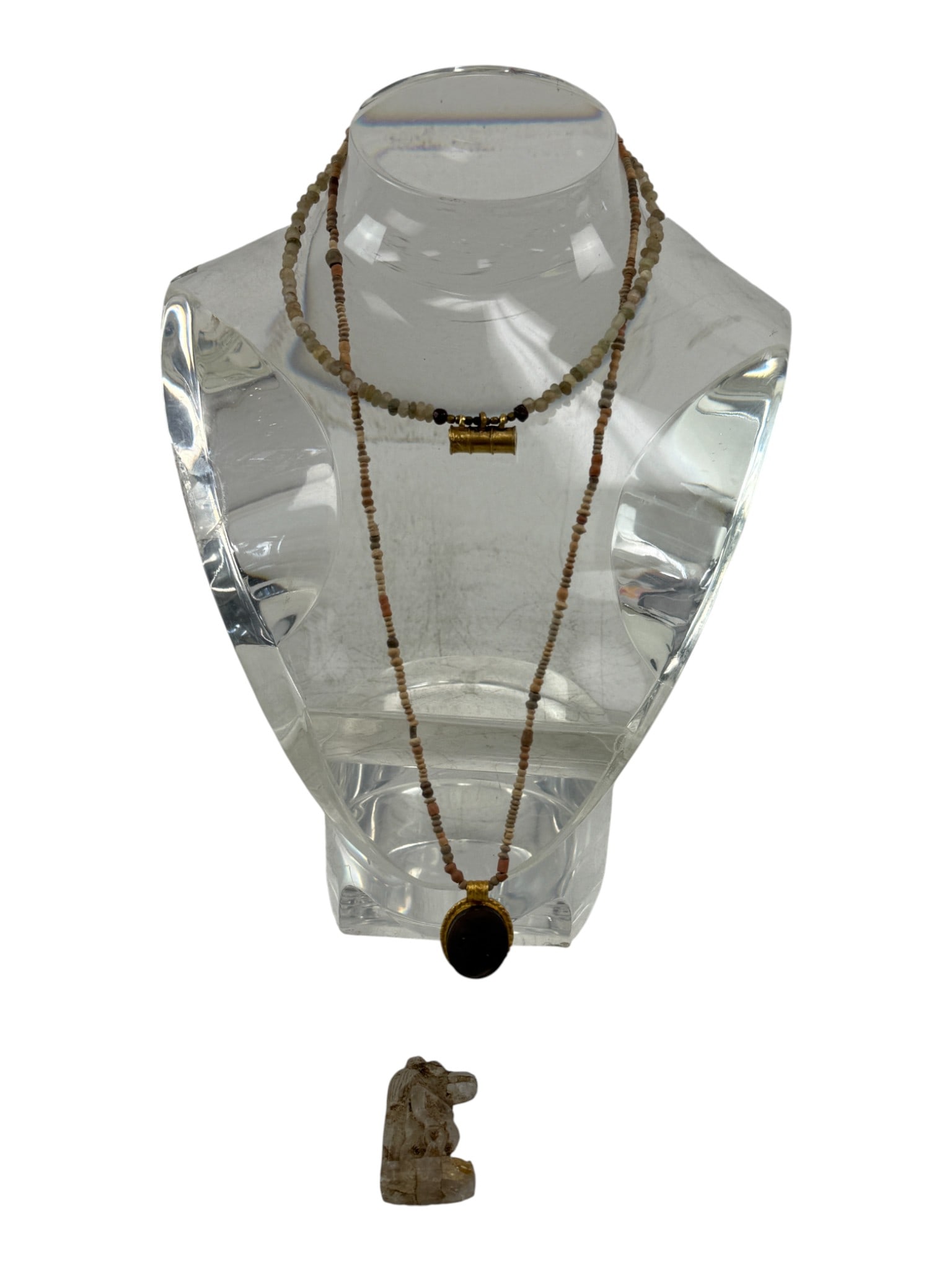 Beaded Necklace with Pendant: Long beaded necklace composed of natural-tone beads with a central oval pendant set in a gold-tone mount. Decorative artisan jewelry piece.