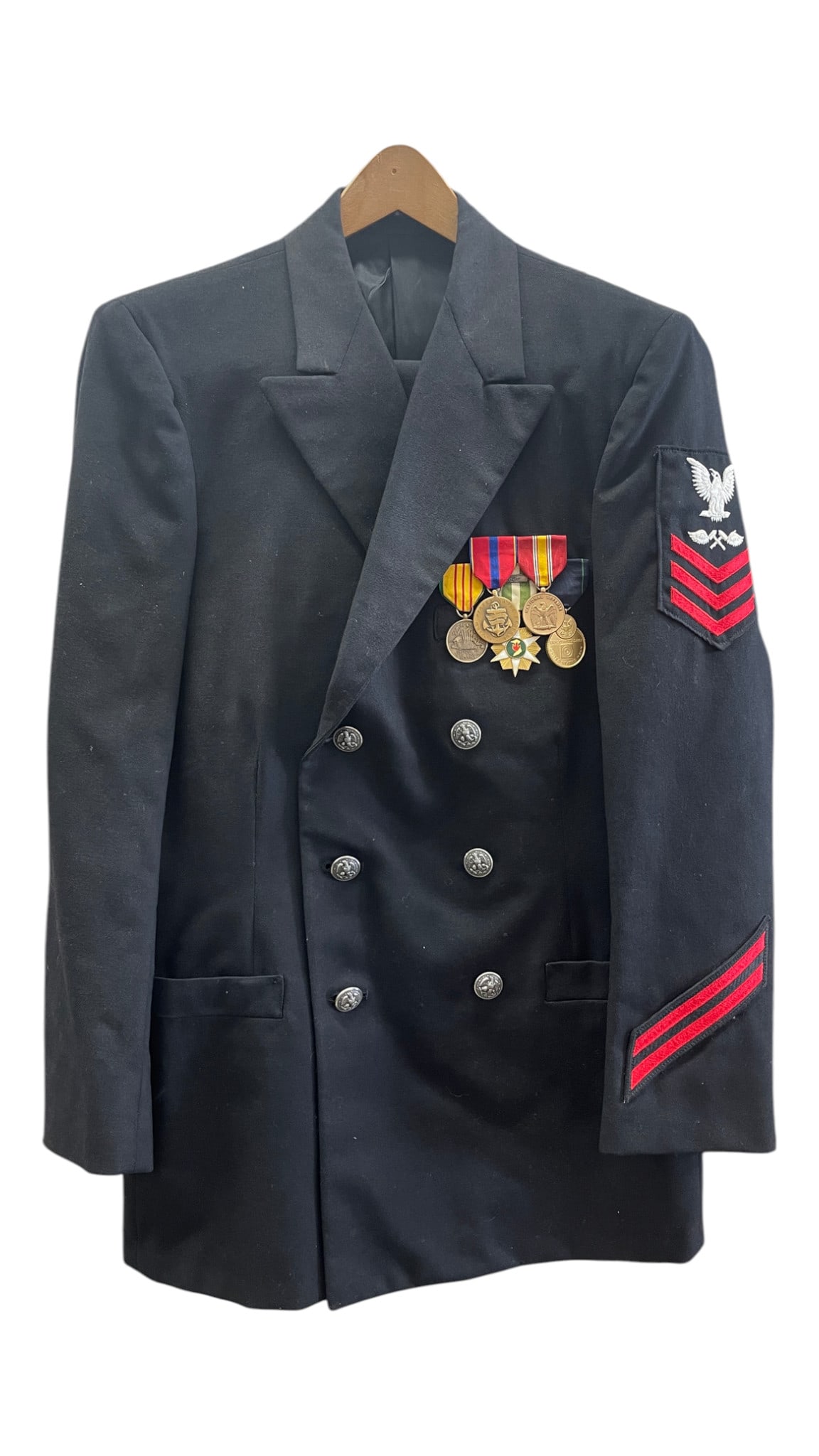 U.S. Navy Dress Uniform Jacket with Medals and Rate Insignia: Dark navy double-breasted U.S. Navy dress uniform jacket featuring sleeve rate insignia, red service stripes, and mounted medal bar. A well-presented military uniform coat with solid display value