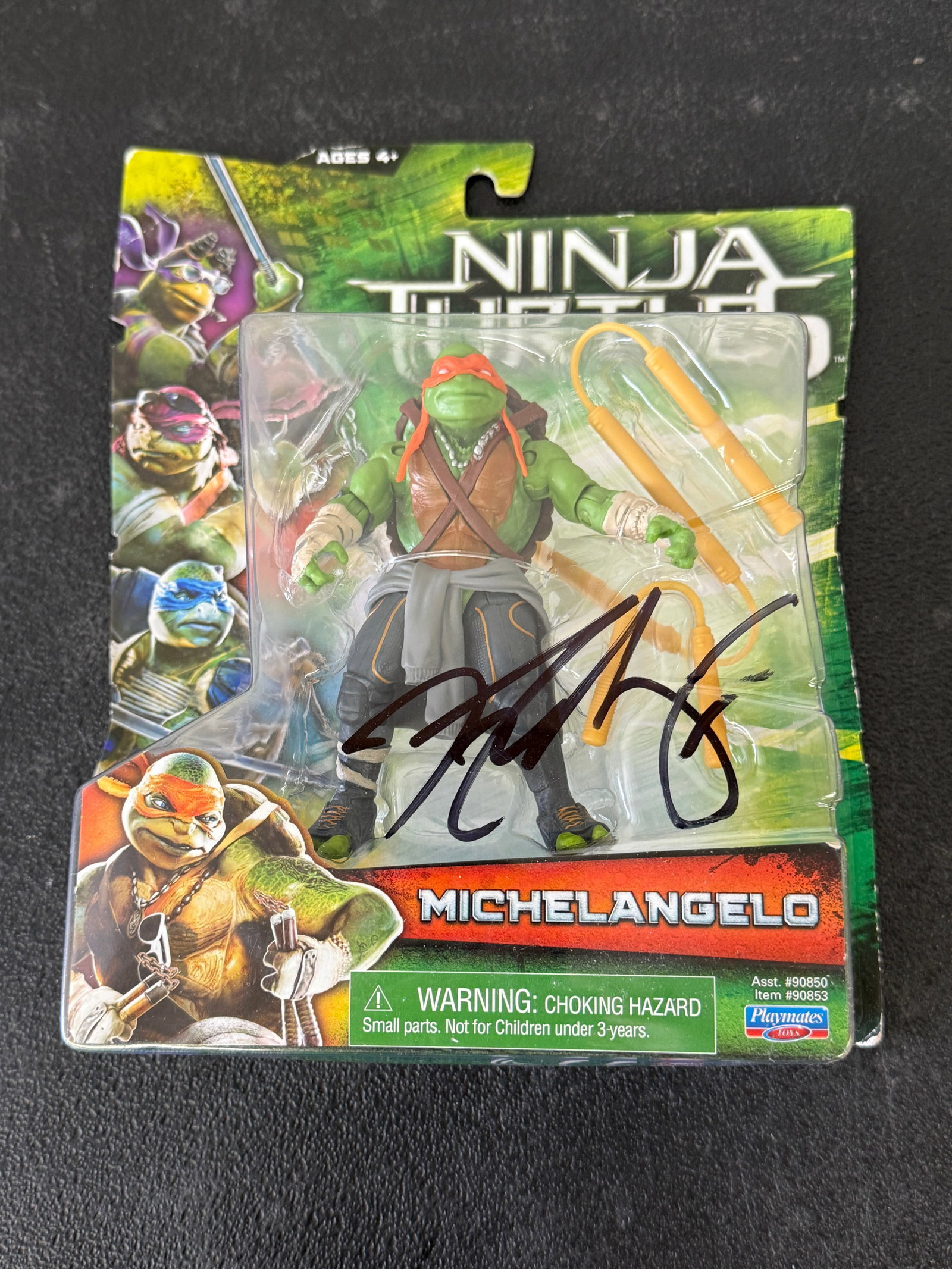 TMNT Michelangelo Action Figure Playmates 2014 Movie Signed Autograph MOC: A Teenage Mutant Ninja Turtles Michelangelo action figure from the 2014 Paramount live-action film, produced by Playmates Toys (Asst. #90850, Item #90853), presented in original sealed blister card pa