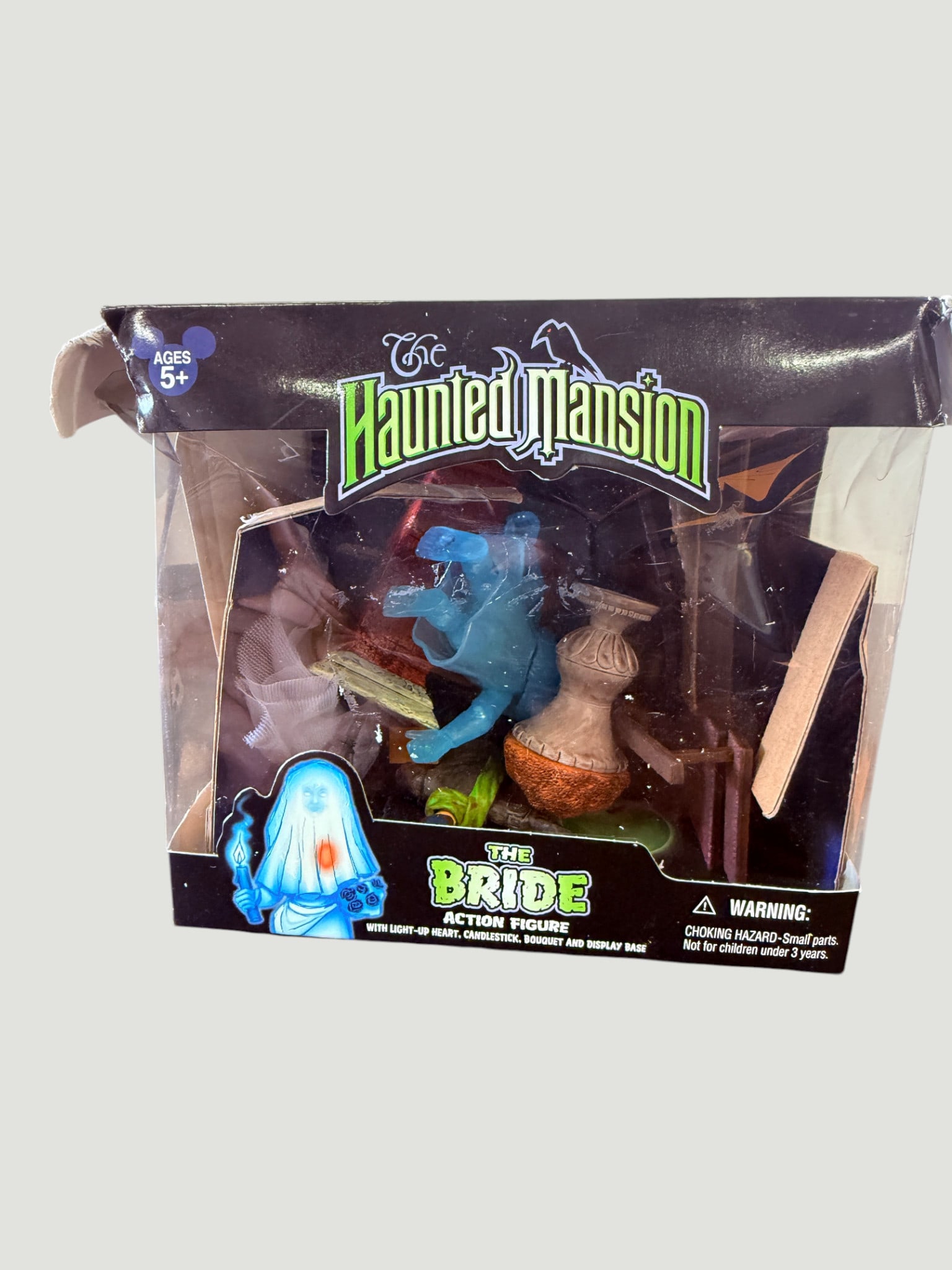Disney Haunted Mansion 'The Bride' Action Figure with Light-Up Heart & Accessories: Official Disney Parks exclusive action figure of The Bride (Constance Hatchaway) from the iconic Haunted Mansion attraction, rendered in translucent blue ghost form. The set includes a light-up beatin