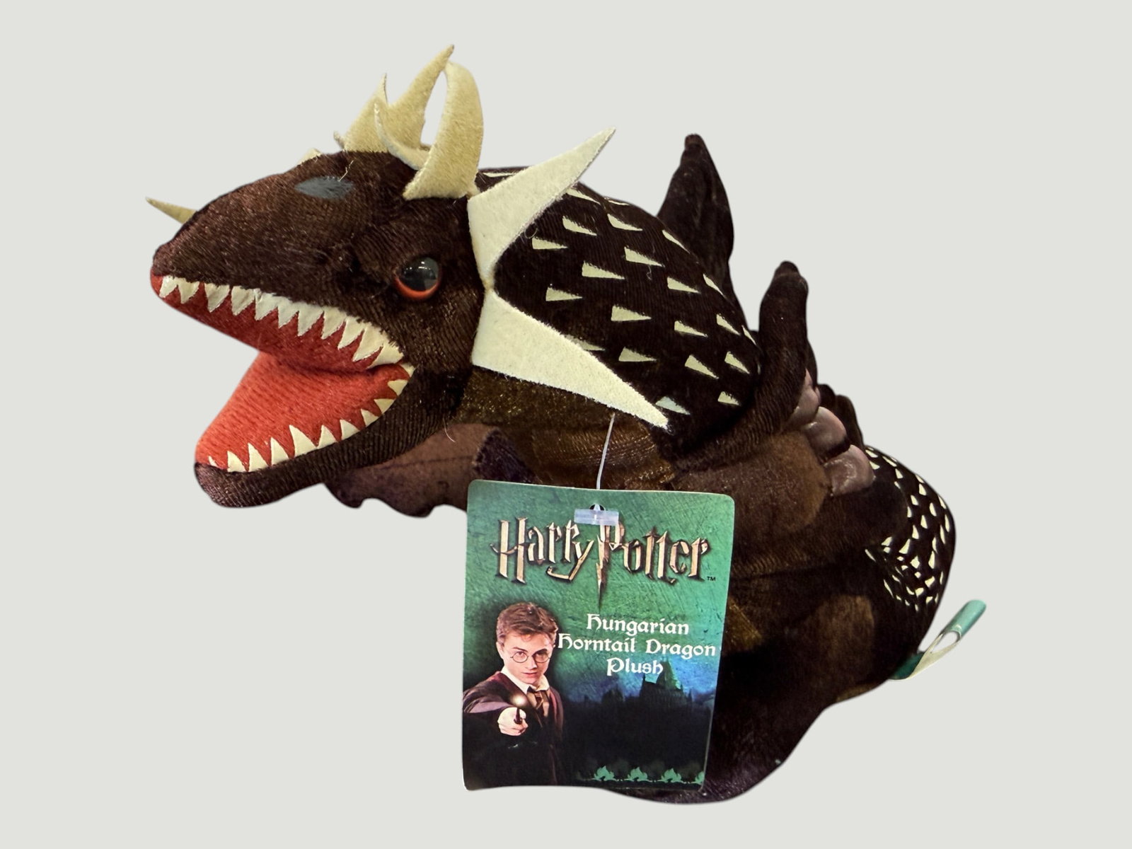 Harry Potter Hungarian Horntail Dragon Plush Toy with Original Tag: Official Harry Potter licensed Hungarian Horntail Dragon plush toy, as featured in Harry Potter and the Goblet of Fire. The plush features detailed dark brown fabric construction with cream/ivory felt