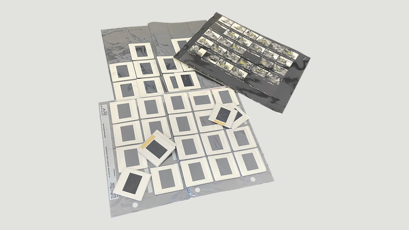 35mm Photographic Slides Collection with Contact Sheet, approx. 30+ Slides: A collection of approximately 30 or more mounted 35mm photographic slides in white cardboard mounts, housed in a clear plastic archival slide sheet, accompanied by a black-and-white contact sheet show
