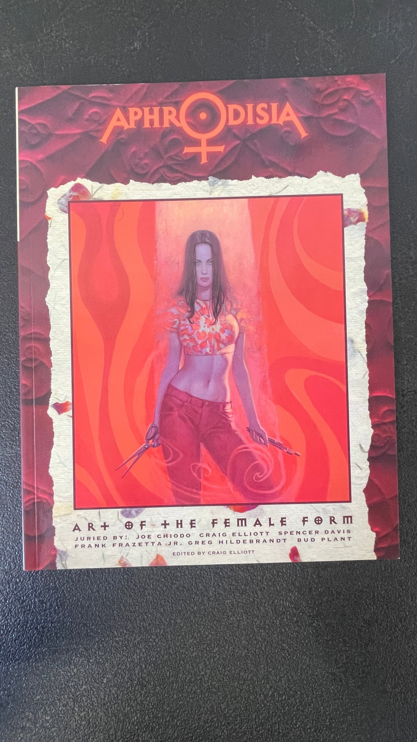 Aphrodisia: Art of the Female Form – Juried Art Book, Ed. Craig Elliott: Aphrodisia: Art of the Female Form is a juried fantasy and figurative art anthology edited by Craig Elliott, featuring works selected by a distinguished panel including Joe Chiodo, Craig Elliott, Spen