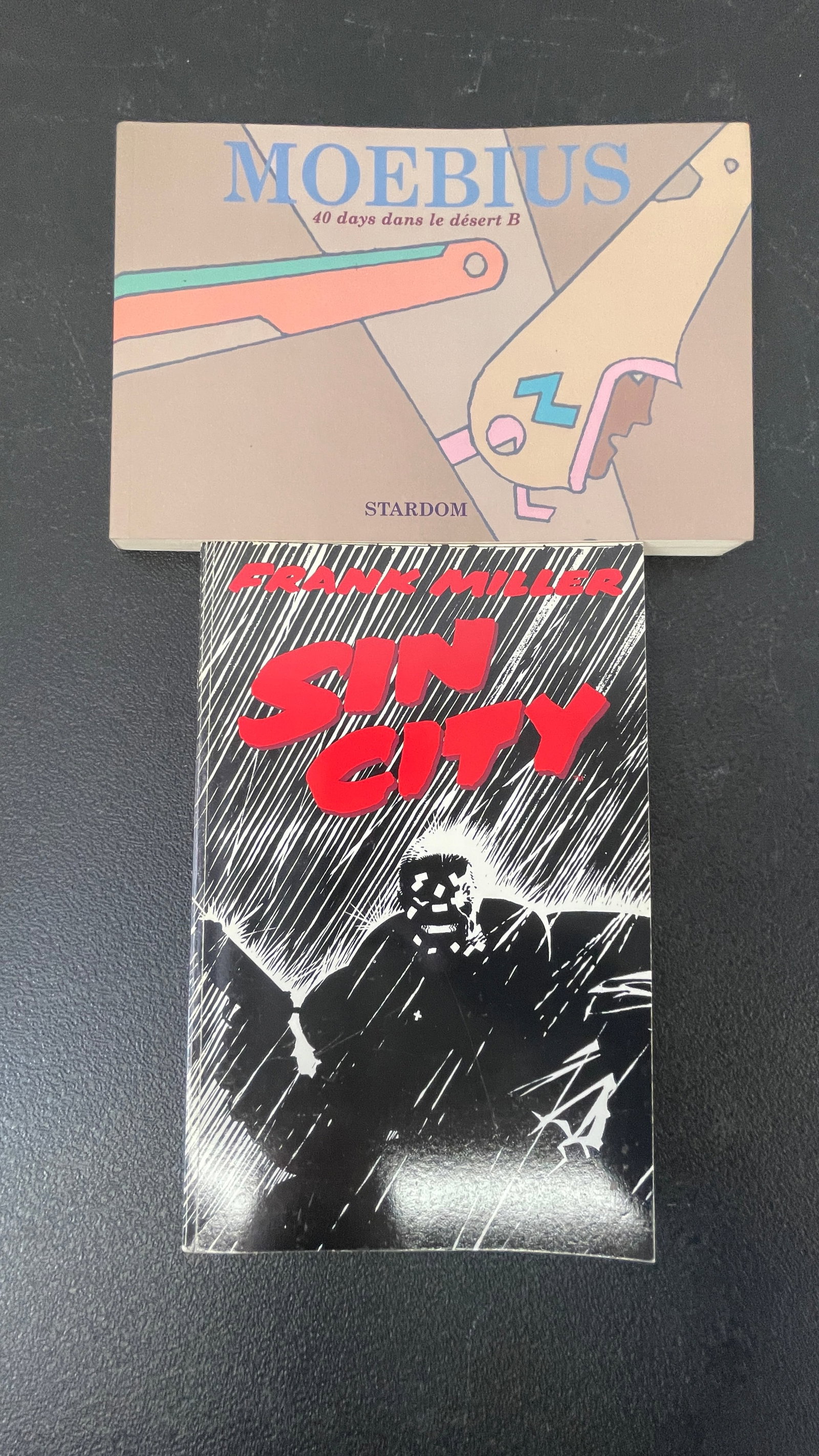 Moebius '40 Days dans le Désert B' Stardom & Frank Miller Sin City HC — 2 Comics: A pair of notable graphic novels: 'Moebius: 40 Days dans le Désert B' published by Stardom, a Japanese edition of the celebrated French artist Jean Giraud (Moebius) featuring his distinctive
