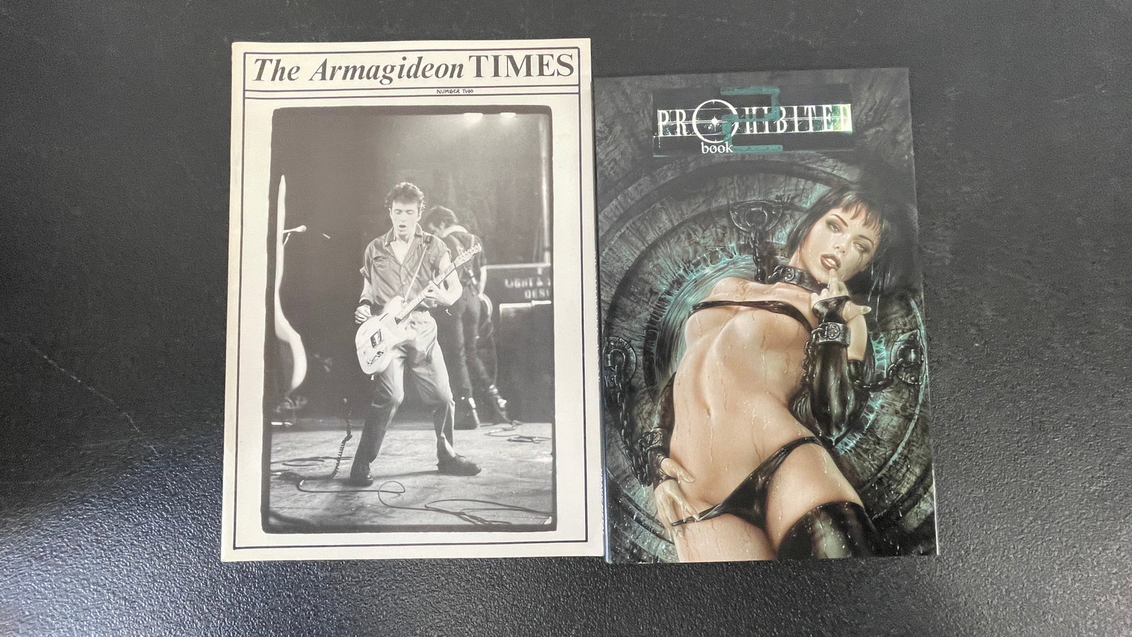 The Armagideon Times #2 Punk Fanzine & Prohibited Book Comic, c.1977/1990s: A pairing of two collectible publications: 'The Armagideon Times' Number Two, a rare punk rock fanzine featuring a black-and-white live concert photograph of a guitarist on its cover, associated with