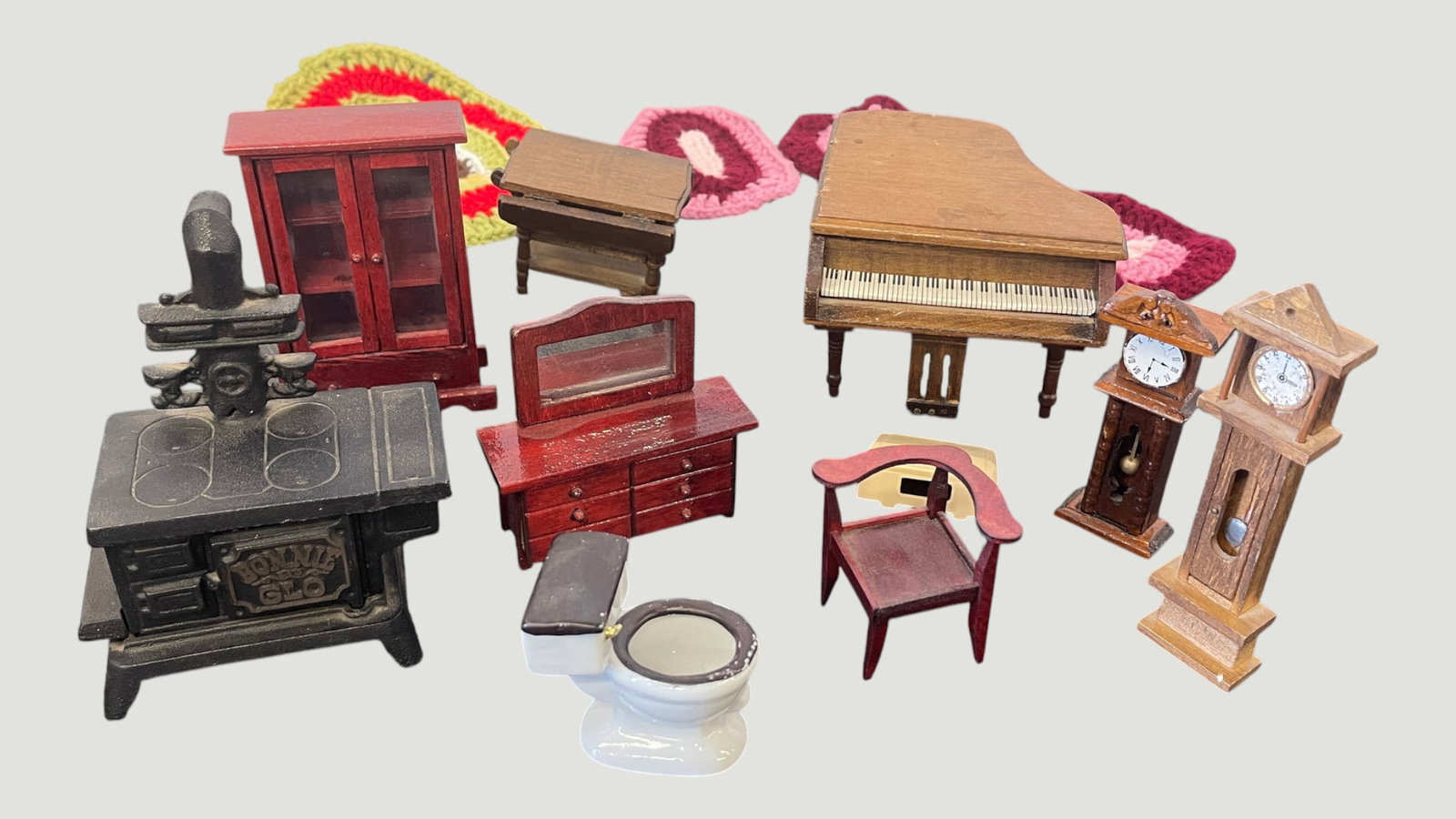 Collection of Dollhouse Miniatures - Furniture & Accessories, approx. 10 pieces: A charming collection of approximately ten dollhouse miniatures representing various rooms of a Victorian-era home, including a cast iron 'Bonnie Glo' wood-burning stove, a grand piano, an upright pia