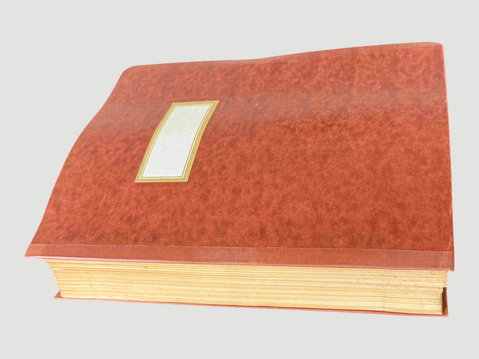 Large Vintage Red Marbled Hardcover Album/Ledger Book with Gold Label: A substantial large-format hardcover album or ledger book featuring a distinctive red marbled paper-covered boards with cloth spine binding, accented by a gold-bordered cream label panel on the front 