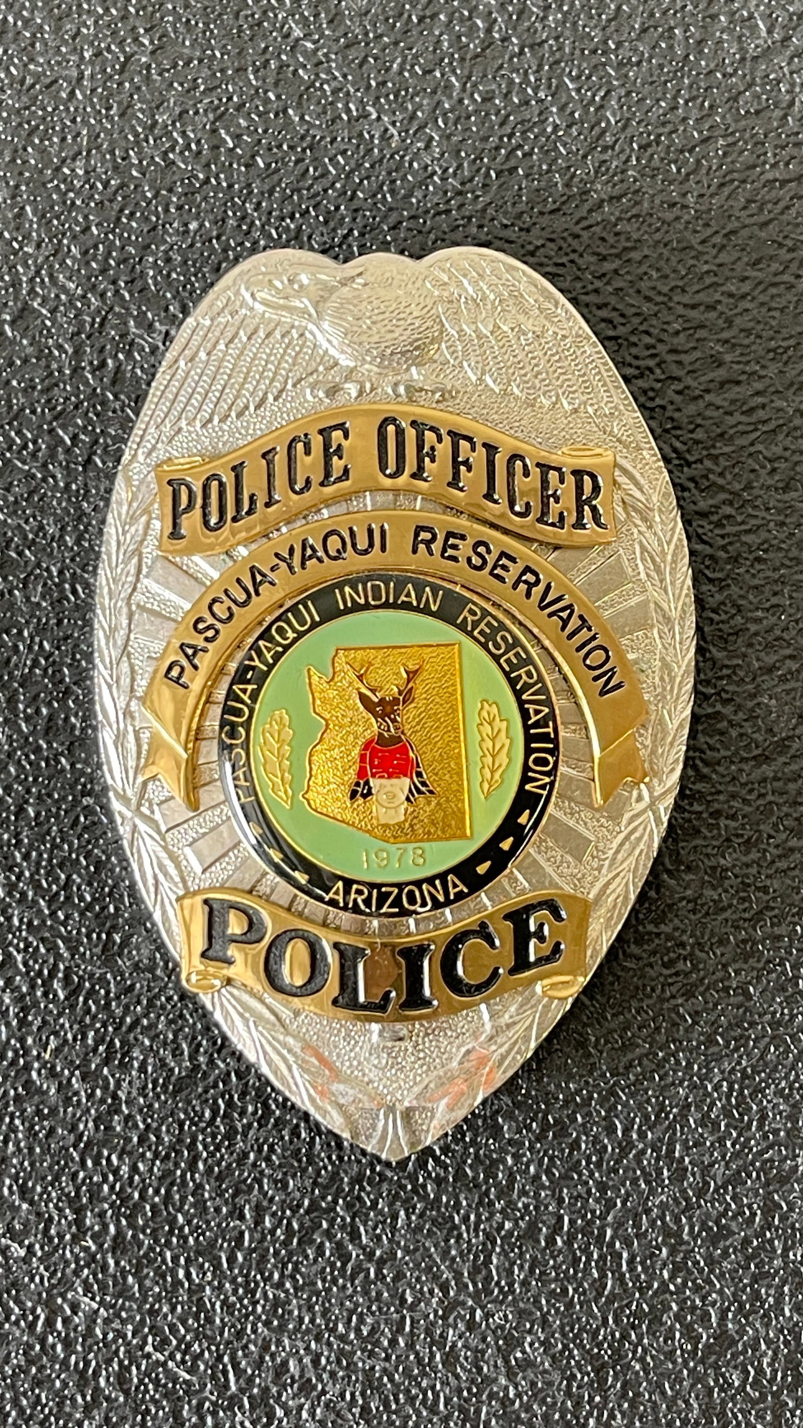 Pascua-Yaqui Indian Reservation Police Officer Badge, Arizona, Est. Post-1978: A silver and gold-toned Police Officer badge issued by the Pascua-Yaqui Indian Reservation, Arizona. The badge features an eagle at the top, a central enamel seal depicting the state of Arizona with a