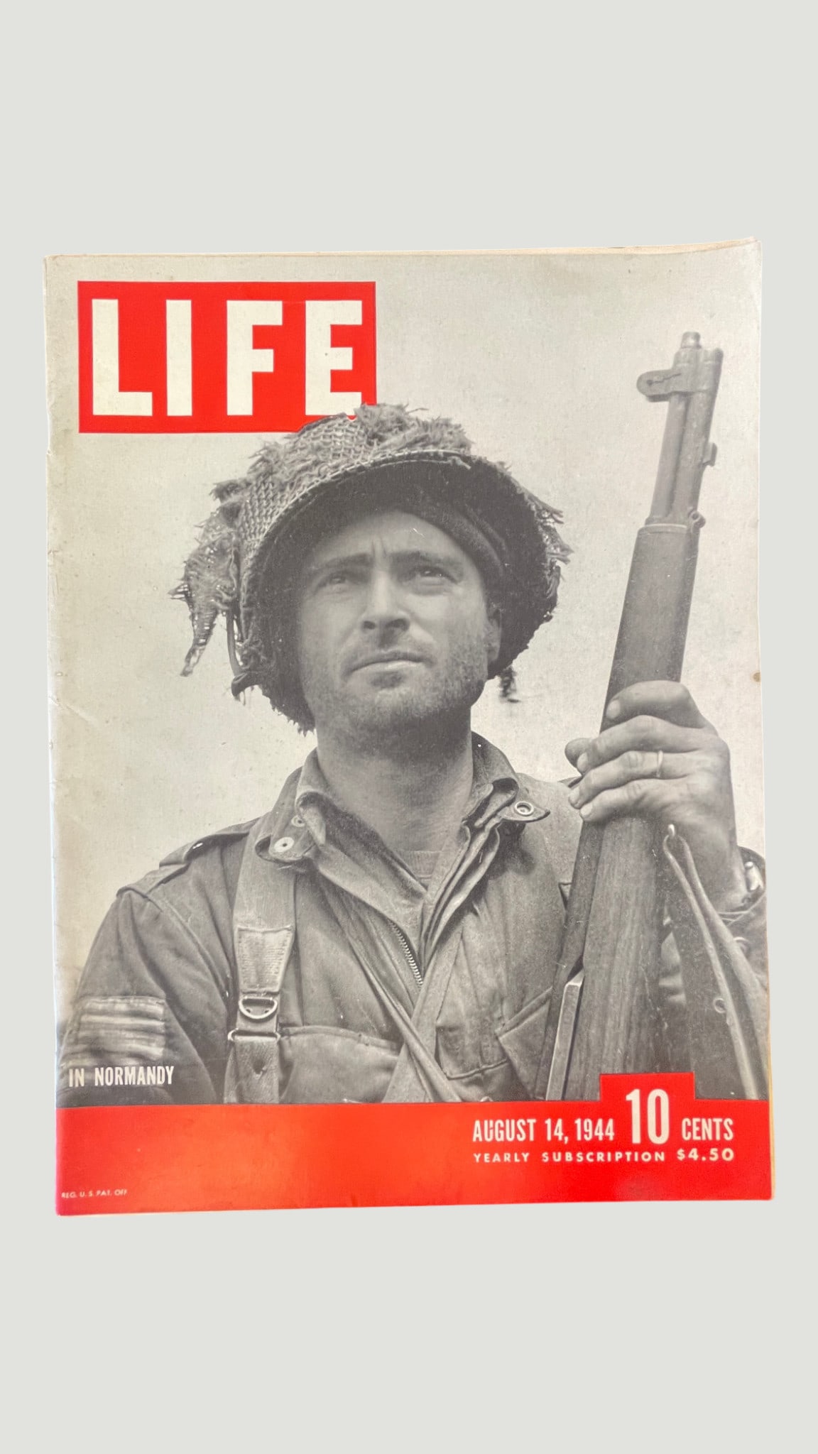 LIFE Magazine August 14, 1944 — WWII Normandy Cover Issue: An original issue of LIFE Magazine dated August 14, 1944, featuring a striking black-and-white cover photograph of an Allied soldier in Normandy, France, holding a rifle and wearing a camouflaged helm
