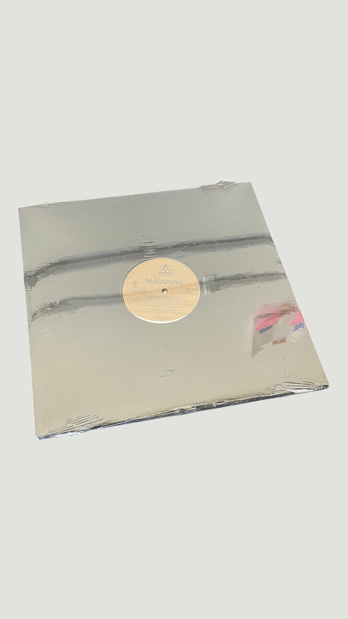 Madonna – Warner Bros. 12" Vinyl Record LP, Disc One Side 1 Promo: A 12-inch vinyl record from Madonna, released on Warner Bros. Records, featuring the Maverick Records triangle logo on the center label. The record is presented in a silver/mirror-finish generic sleev