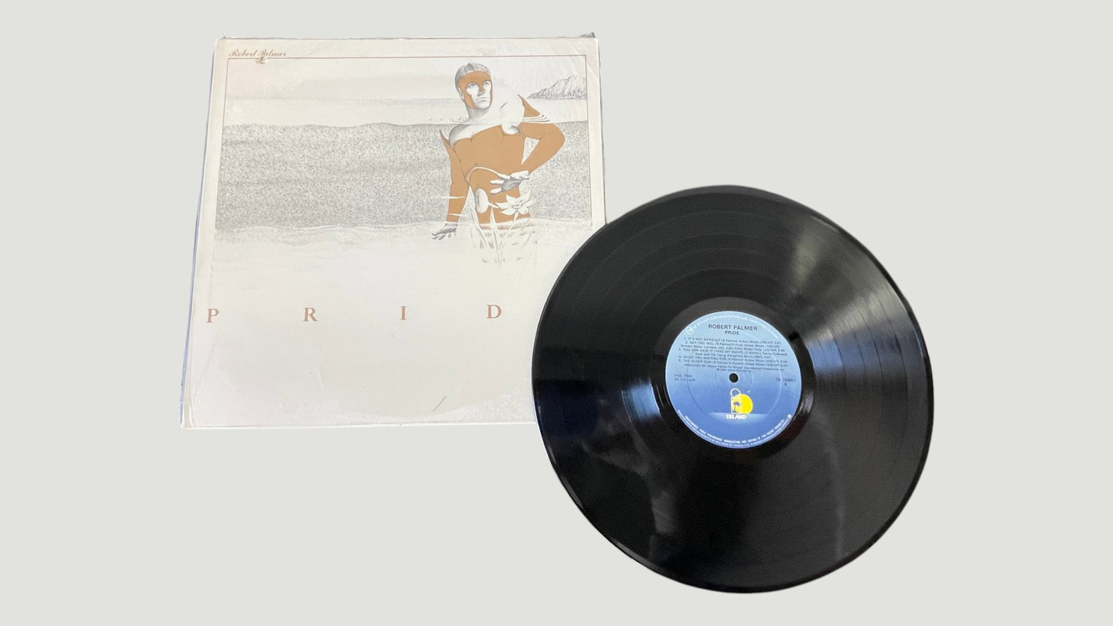 Robert Palmer 'Pride' Vinyl LP Record Island Records 1983: Robert Palmer's sixth studio album 'Pride', released in 1983 on Island Records. This is the UK pressing featuring the distinctive illustrated cover artwork depicting a golden figure emerging from wate