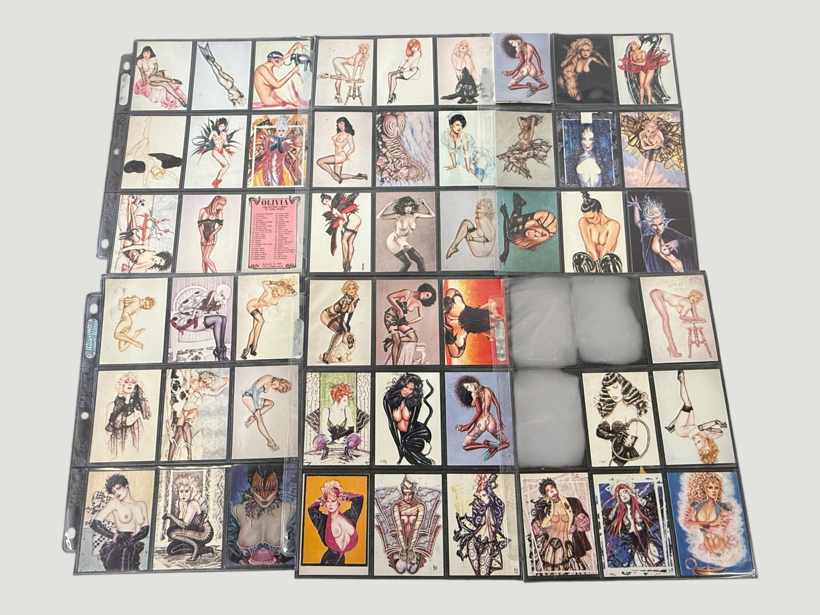 Olivia De Berardinis Collector Cards Complete/Near Set 1992 Comic Images Pin-Up: A collection of Olivia De Berardinis collectible trading cards, published by Comic Images circa 1992, stored in plastic binder pages. The cards feature the celebrated pin-up and fantasy artwork of Oli